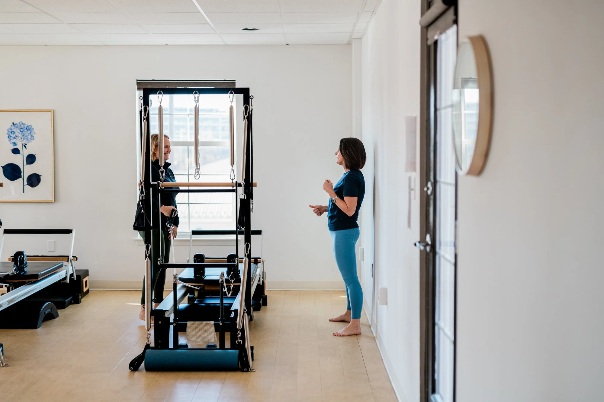 Private Pilates instruction at The Pilates Place with Pilates equipment, hardwood floors, and light-colored walls.