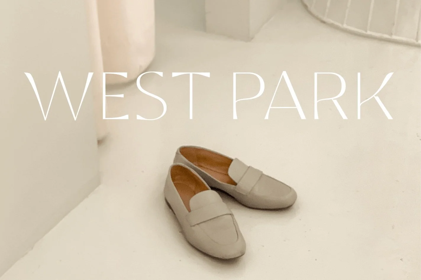 Ein Paar Schuhe steht auf einem weißen Boden vor einem weißen Hintergrund, mit dem Schriftzug 'WEST PARK' darüber.