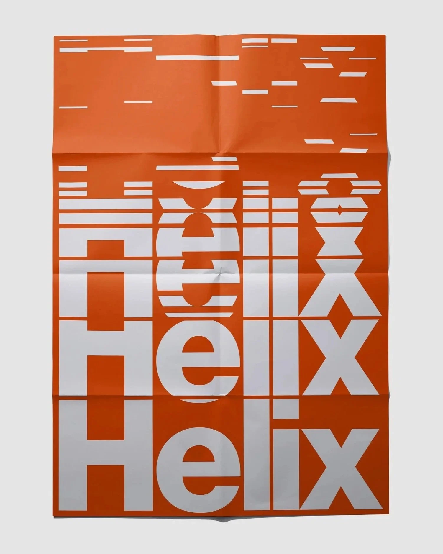 Ein aufgeklebtes Plakat mit fallengelassener, zerknitterter orangefarbener Hintergrundfarbe, auf dem große weiße Buchstaben das Wort 'HELIX' in einer vertikalen Anordnung bilden.