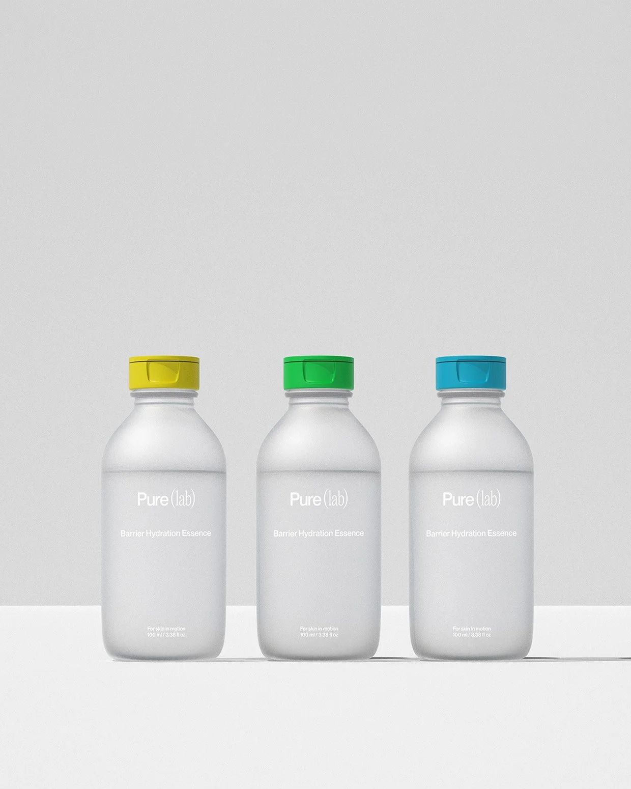 Drei Flaschen mit weißem Körper und gelbem, grünem und blauen Verschluss, beschriftet mit "Pure(lab) Barrier Hydration Essence", gegen einen hellgrauen Hintergrund.