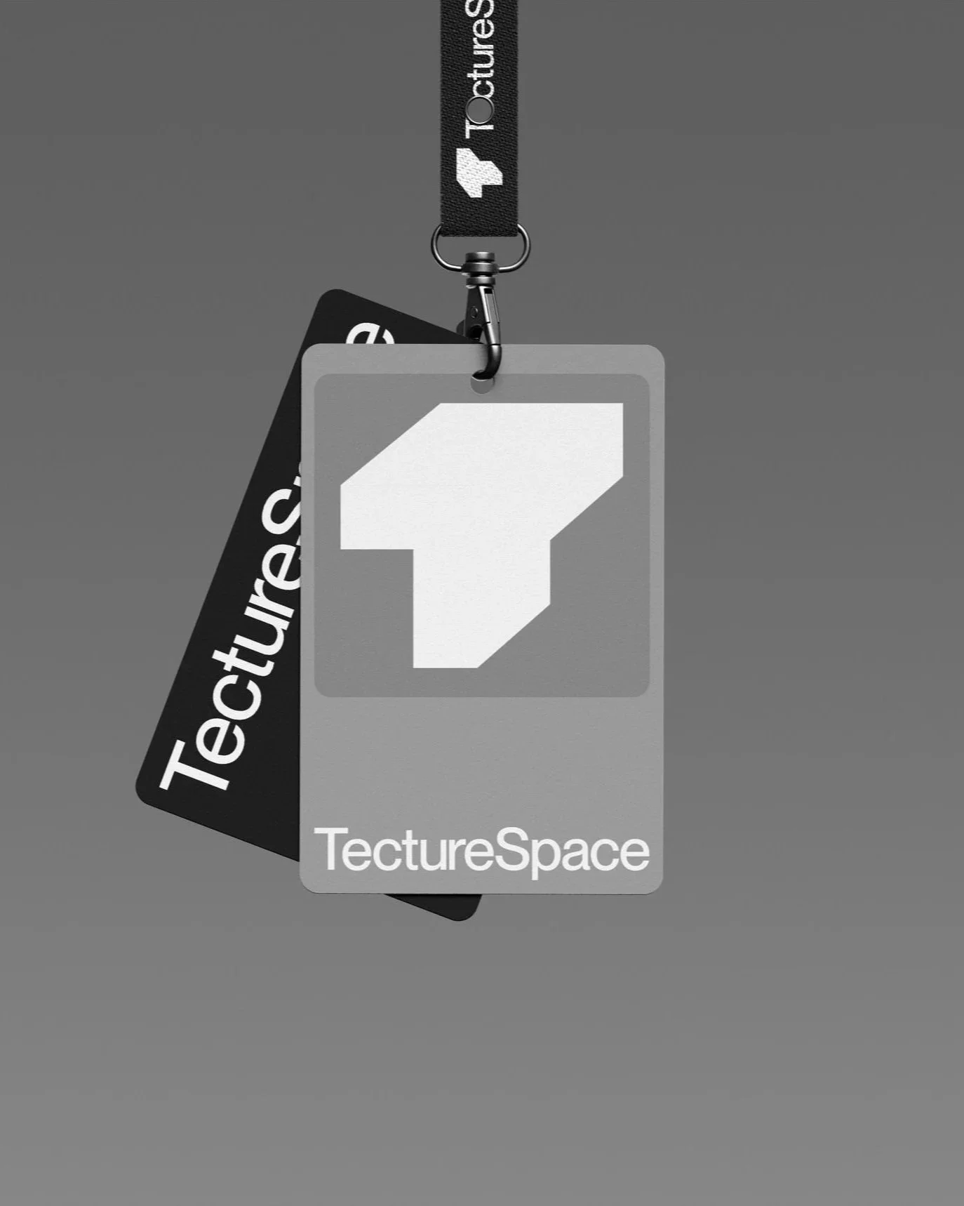 Ein grauer Hintergrund mit einem gehängten Ausweisschild, das die Marke 'TectureSpace' trägt, und einem schwarzen Lanyard mit Weißschrift und Logo.