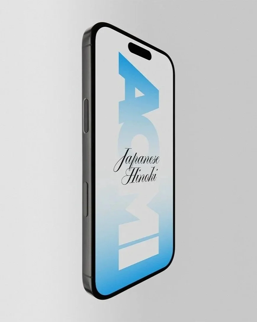 Ein modernes Smartphone mit dem Text 'Japanese Hinoki' auf dem Bildschirm, vor einem zweifarbigen Hintergrund in Grau und Weiß.