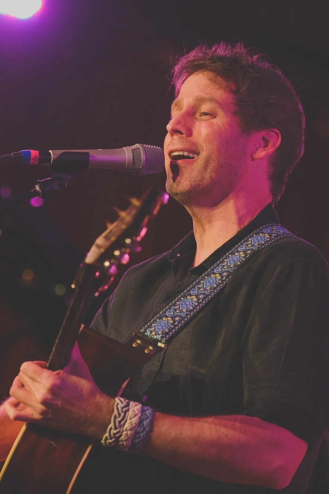 Photo of Jesse Terry singing and playing acoustic guitar
