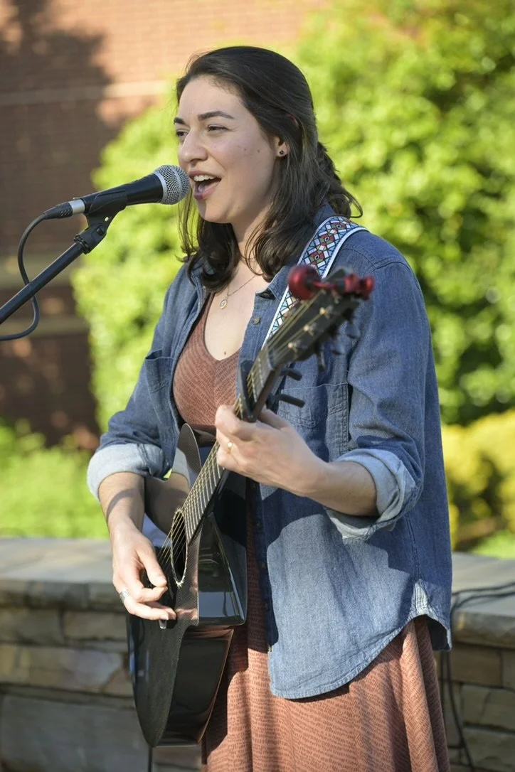 Teni Rane playing acoustic guitar.