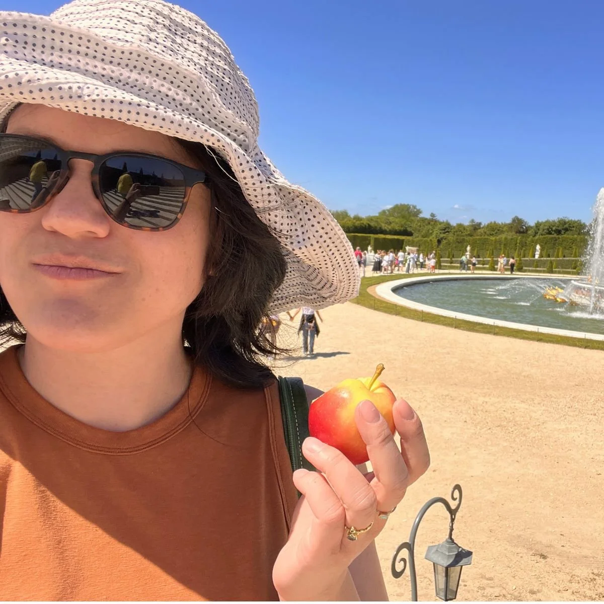 A woman eating an apple in Paris at Versailles