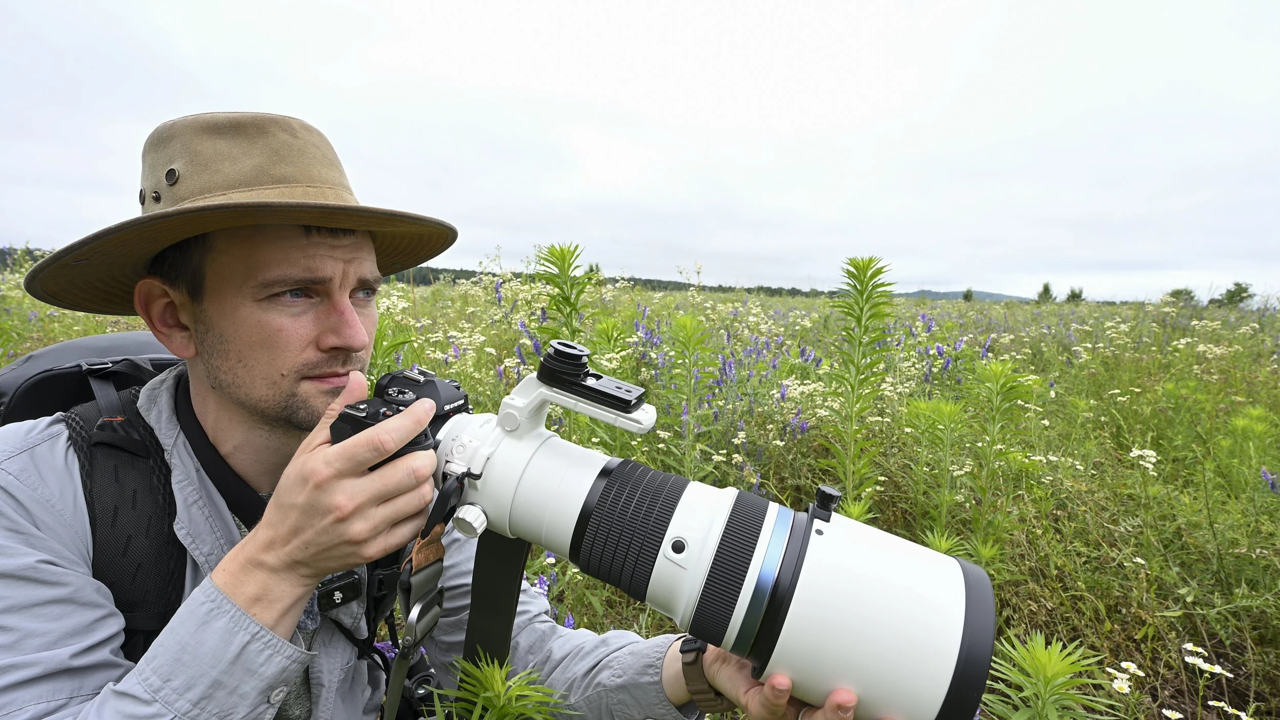 wildlife photographer using OM-1 Mark II and 150-400mm f/4.5 lens to photograph birds