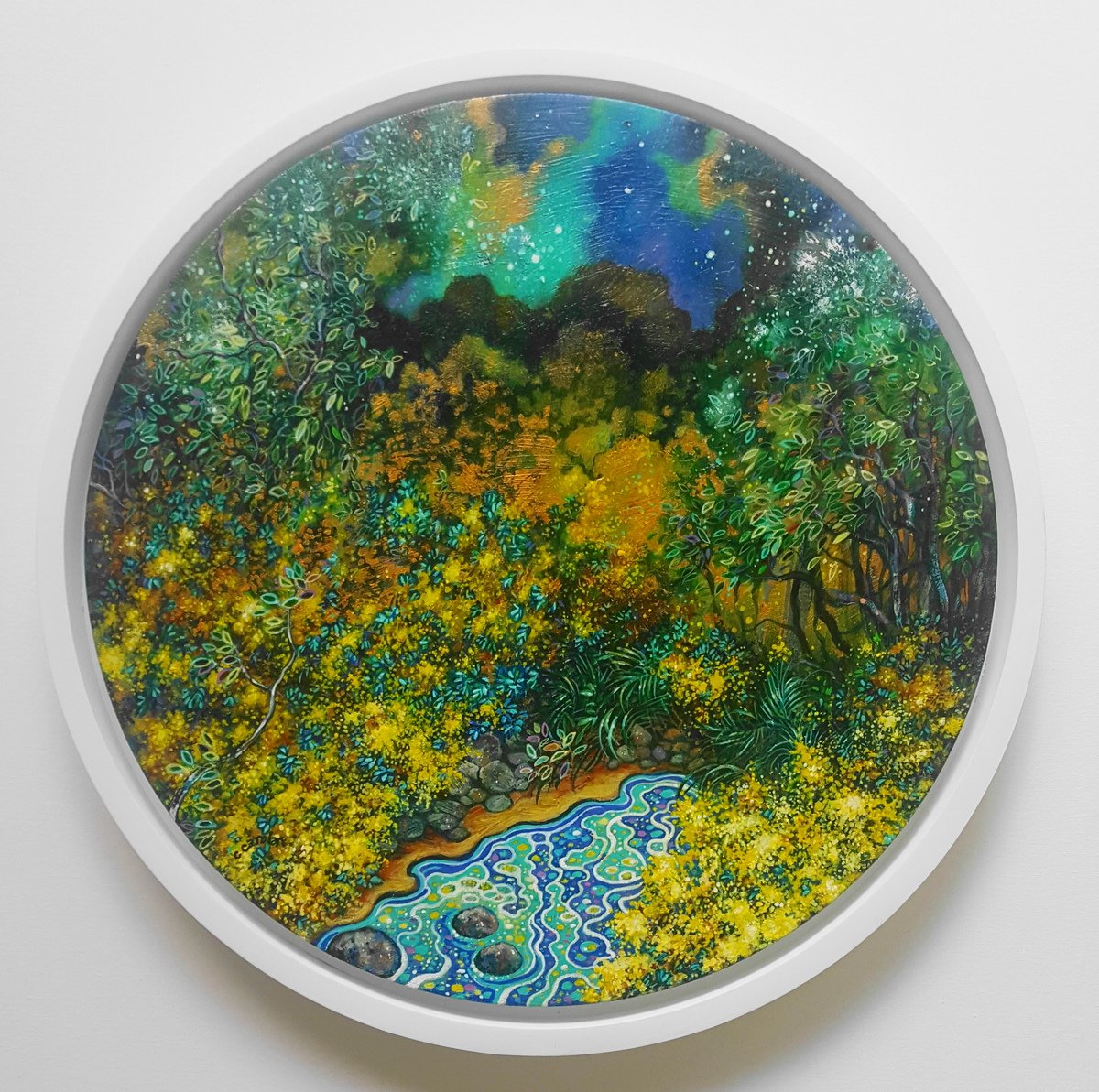 Circular artwork depicting a vibrant, detailed landscape with dense greenery, yellow foliage, and a small, colorful pond at the bottom. The background features a luminous night sky with stars and auroras in various shades of blue and green.