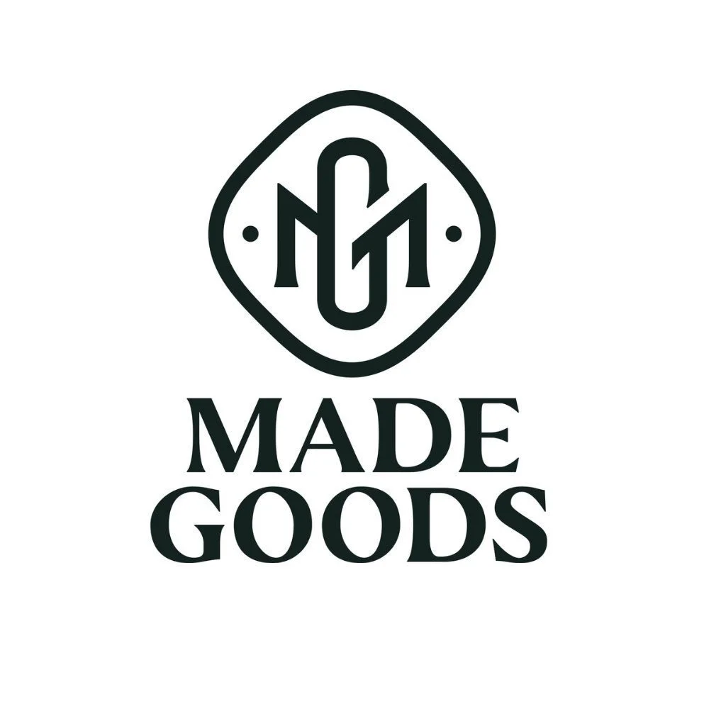 A black and white logo with a circular emblem and the words "Made Goods" below it.
