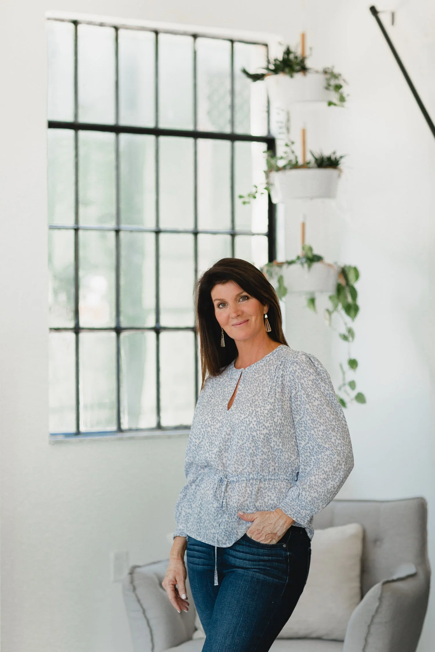 Gail Gibson, founder of Tampa Home Look, standing in a modern living space with natural light and vertical planter decor.