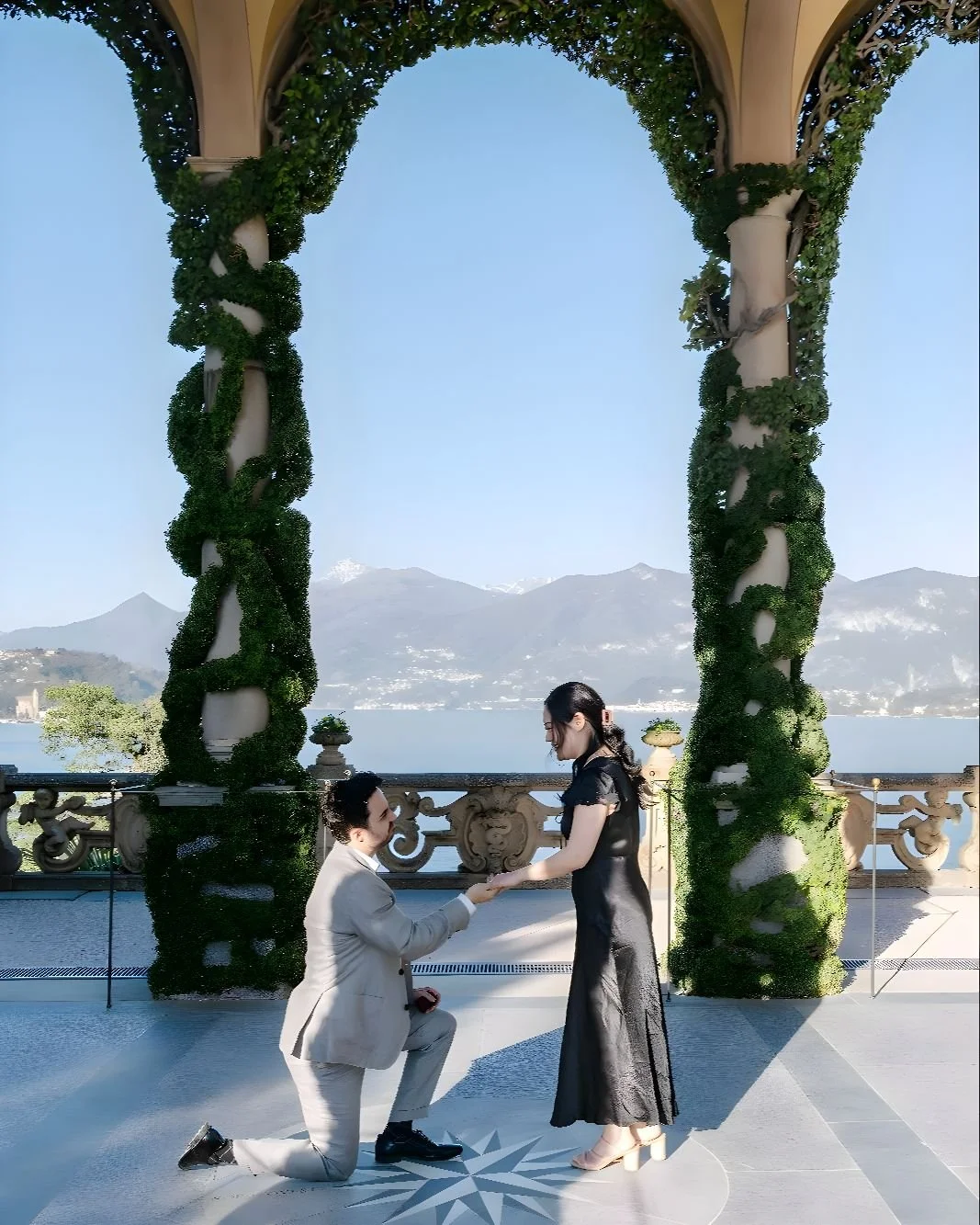Lake Como proposal at Villa del Balbianello, photographed at the slow hour before sunset.
Cole chose the loggia &mdash; the one with the vine-wrapped columns and the compass rose set into the floor. He knelt on Nord-Ovest, the lake pointing west behi