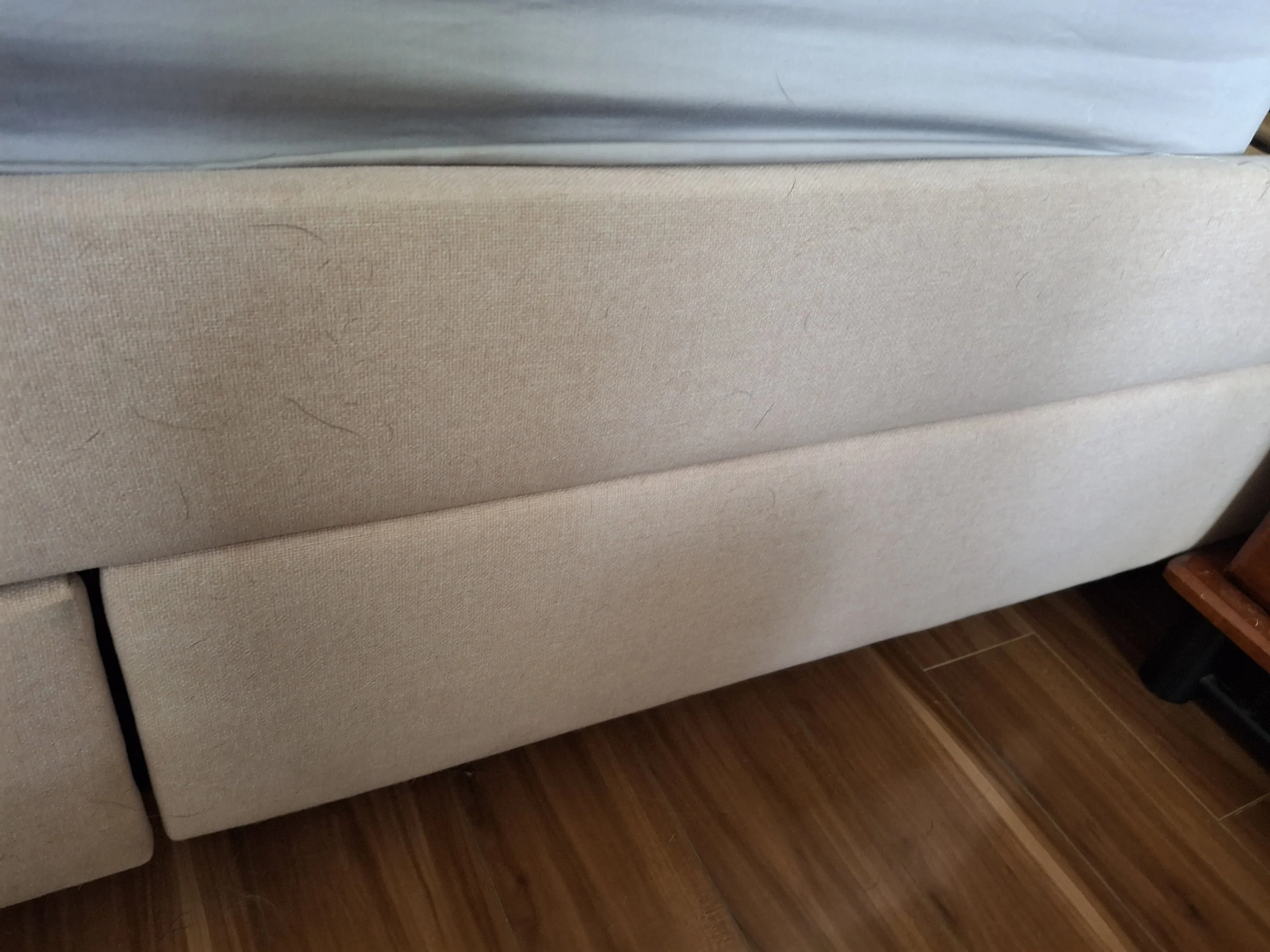 A "before" photo showing an upholdstered bed with visible pet hair 