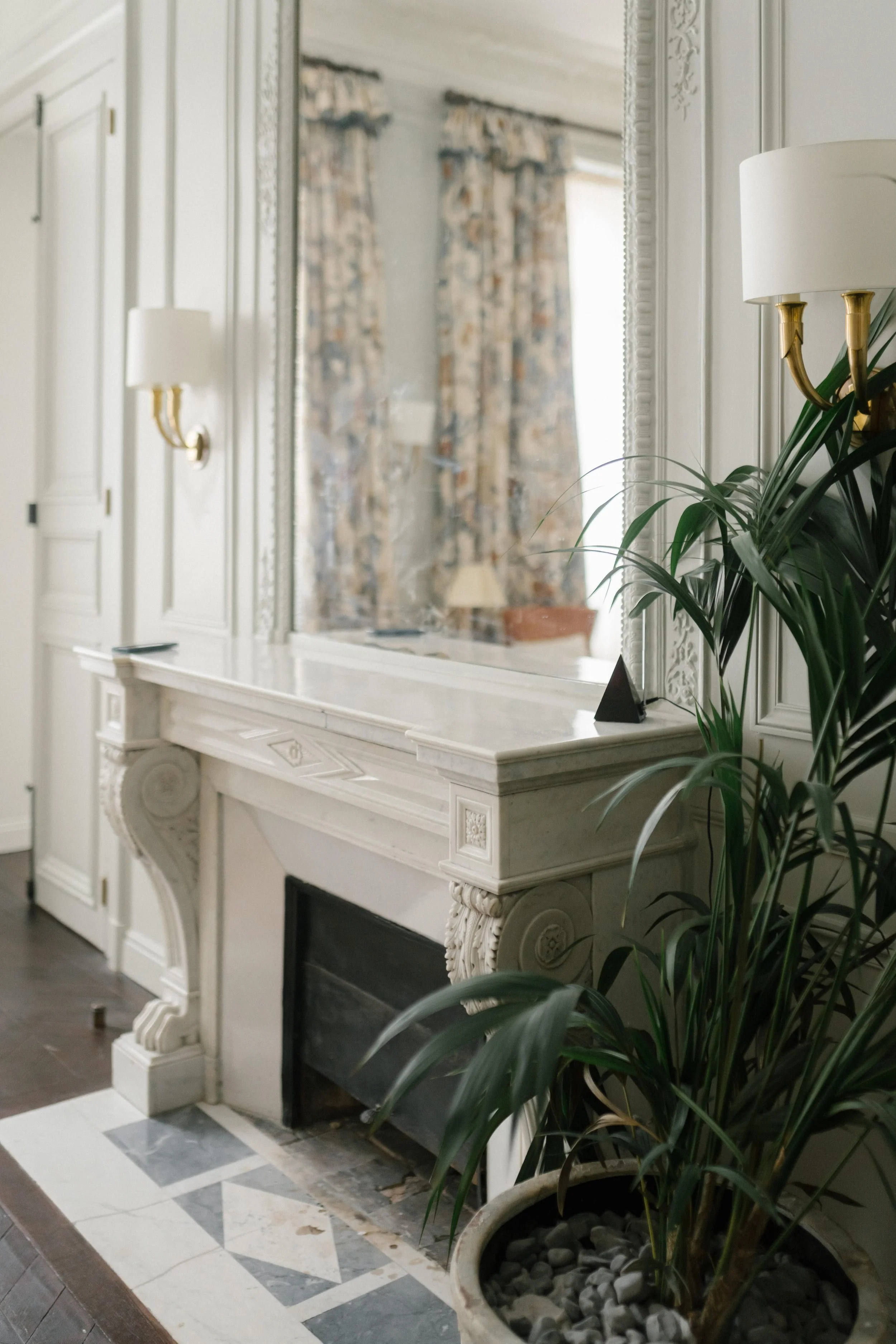 elegant marbel fireplace with a plant and lamps