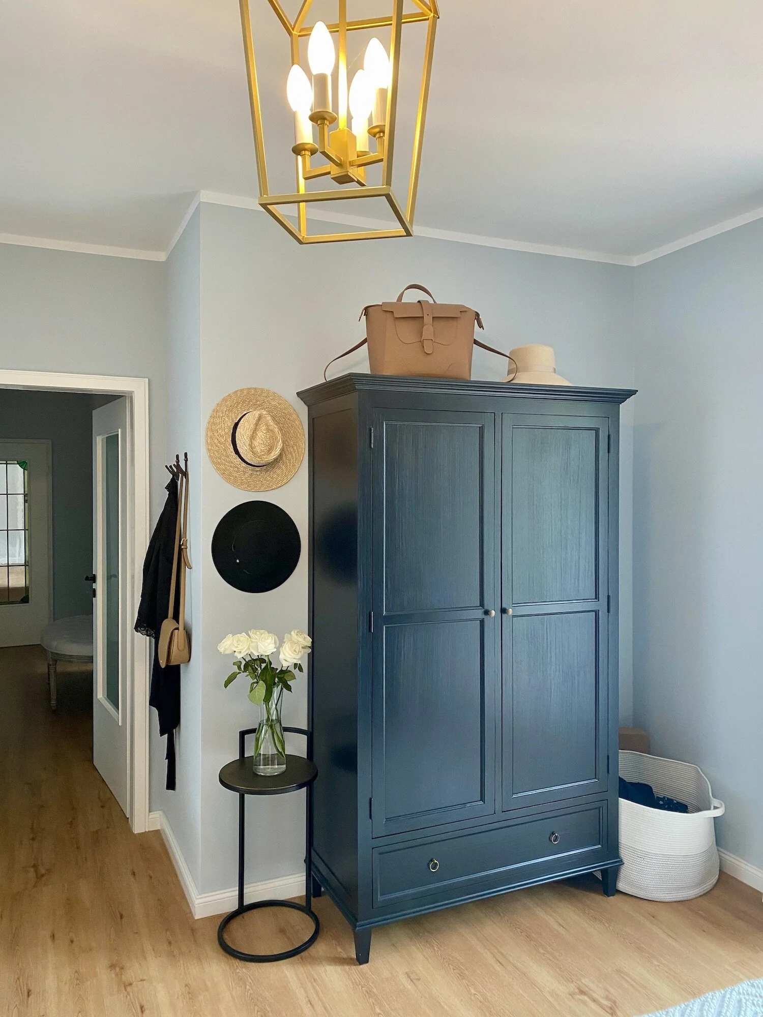 hats on wall for decor in blue bedroom dressing area.jpeg