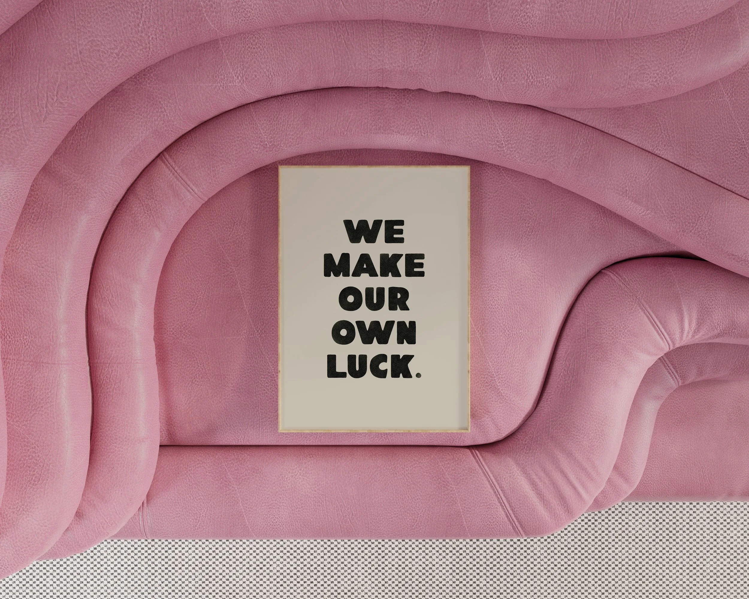 Pink upholstered furniture with a sign that says 'We make our own luck'.