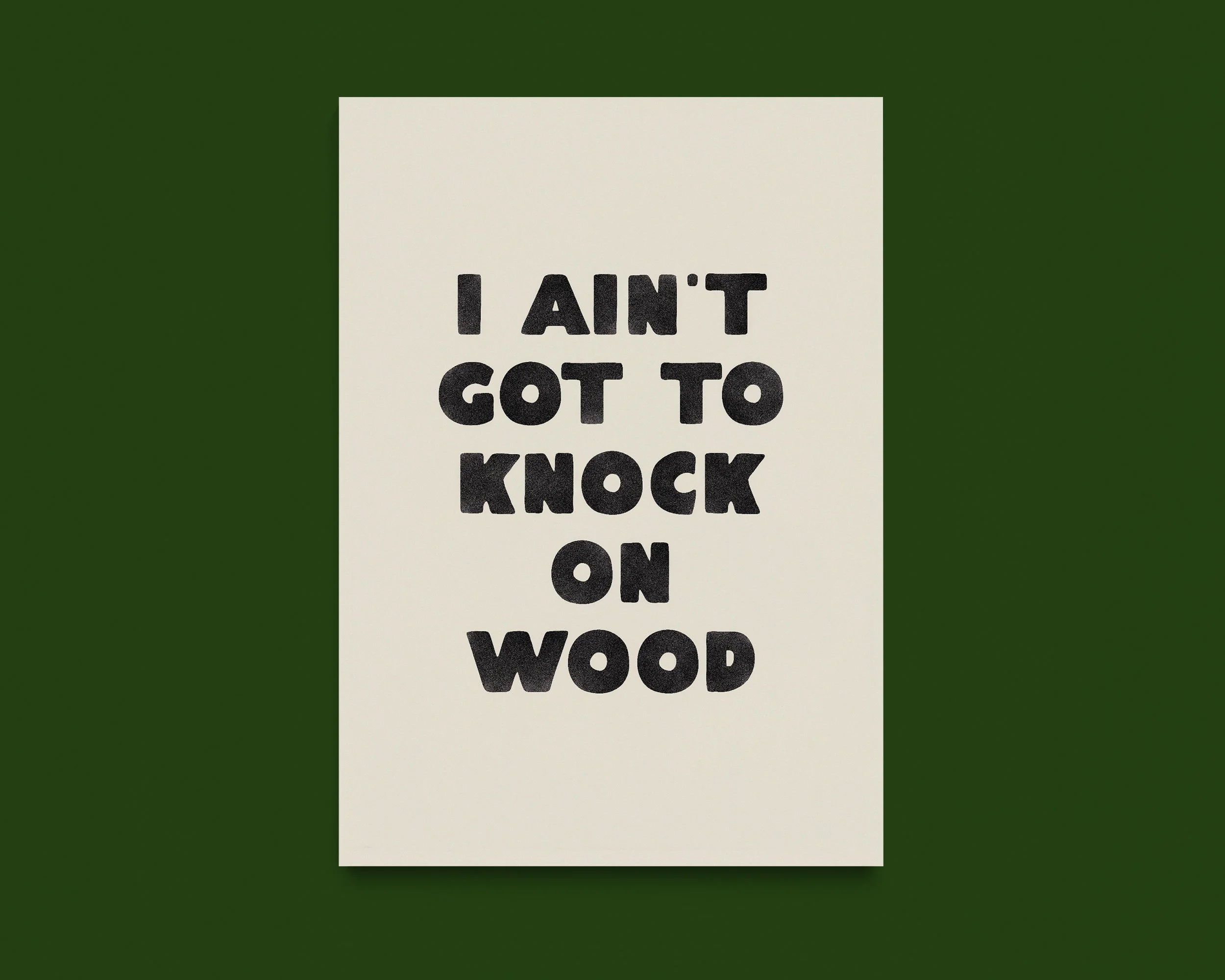 A white sign with black text that reads, "I AIN'T GOT TO KNOCK ON". The sign is center on a green background.