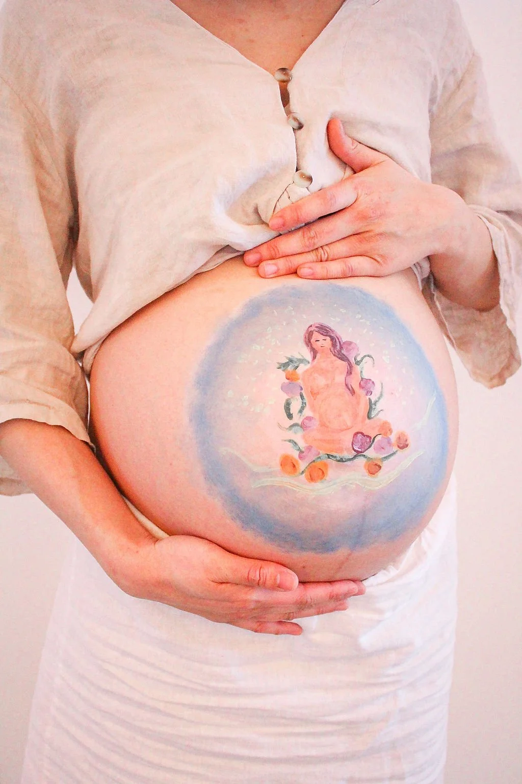 Une femme enceinte à la retraite prénatale de Soline avec un dessin peint sur son ventre.