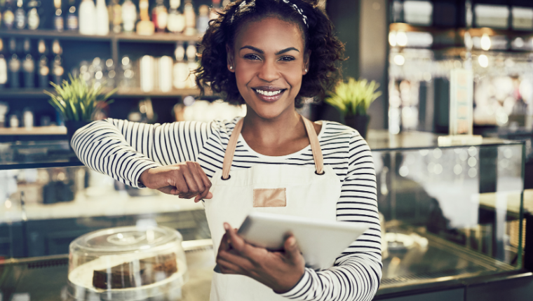 A smiling small business owner utilzes a customer attraction system.