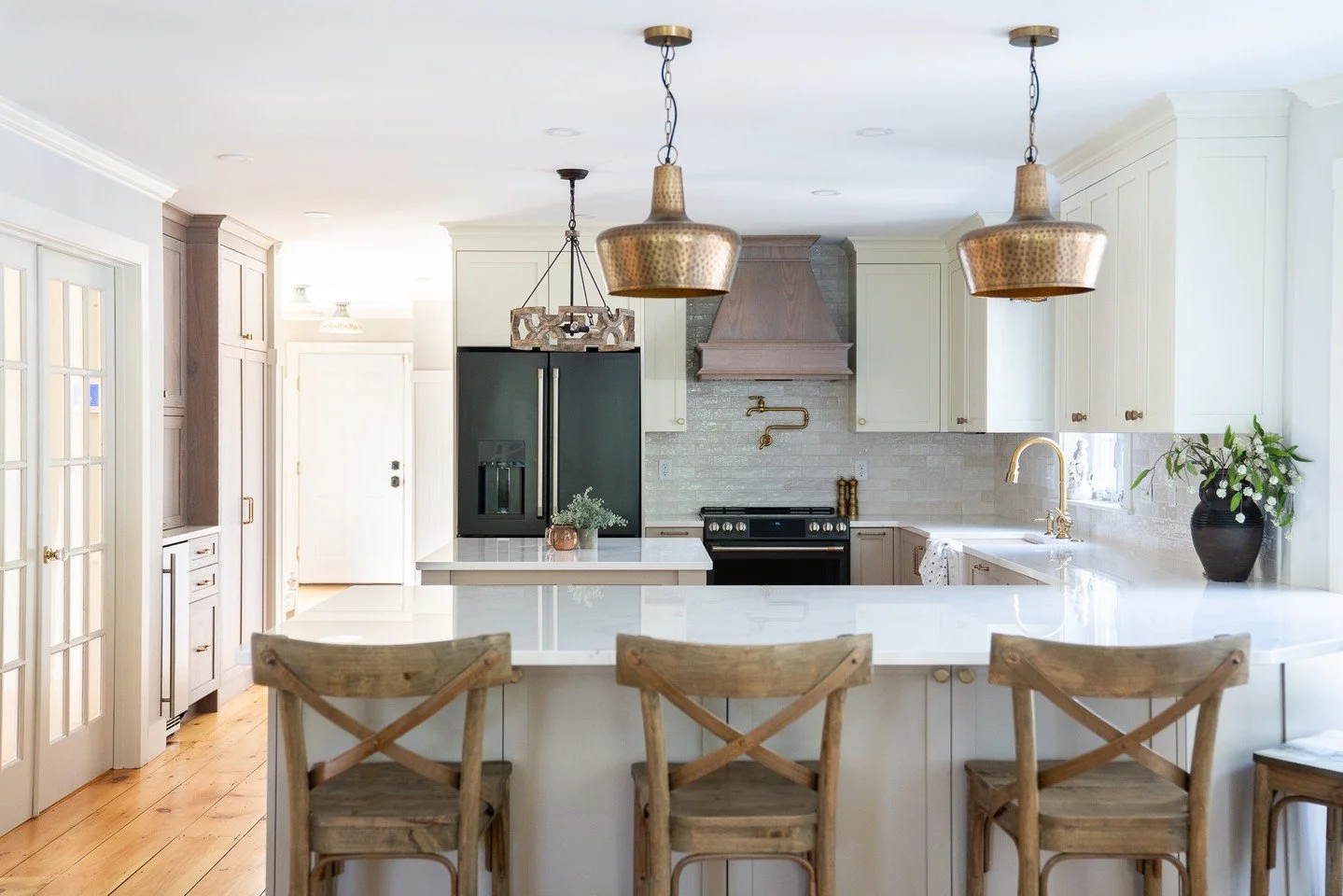 We love how this Scarborough kitchen came together. From the soft white cabinetry and custom wood accents to the warm brass fixtures and beadboard detail in the entryway, every element adds depth and character. A timeless blend of charm and function.