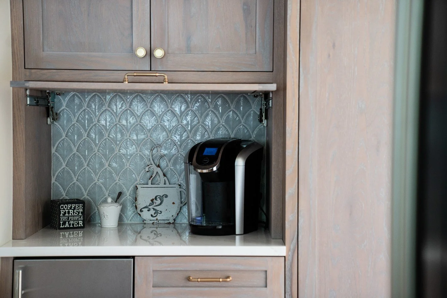 This hidden coffee station is one of our favorite details. Behind a top-hinged pocket door, a soft blue tile backdrop, ice maker, and custom storage create the perfect spot for morning routines. A beautiful balance of function and design. #arcadiakit