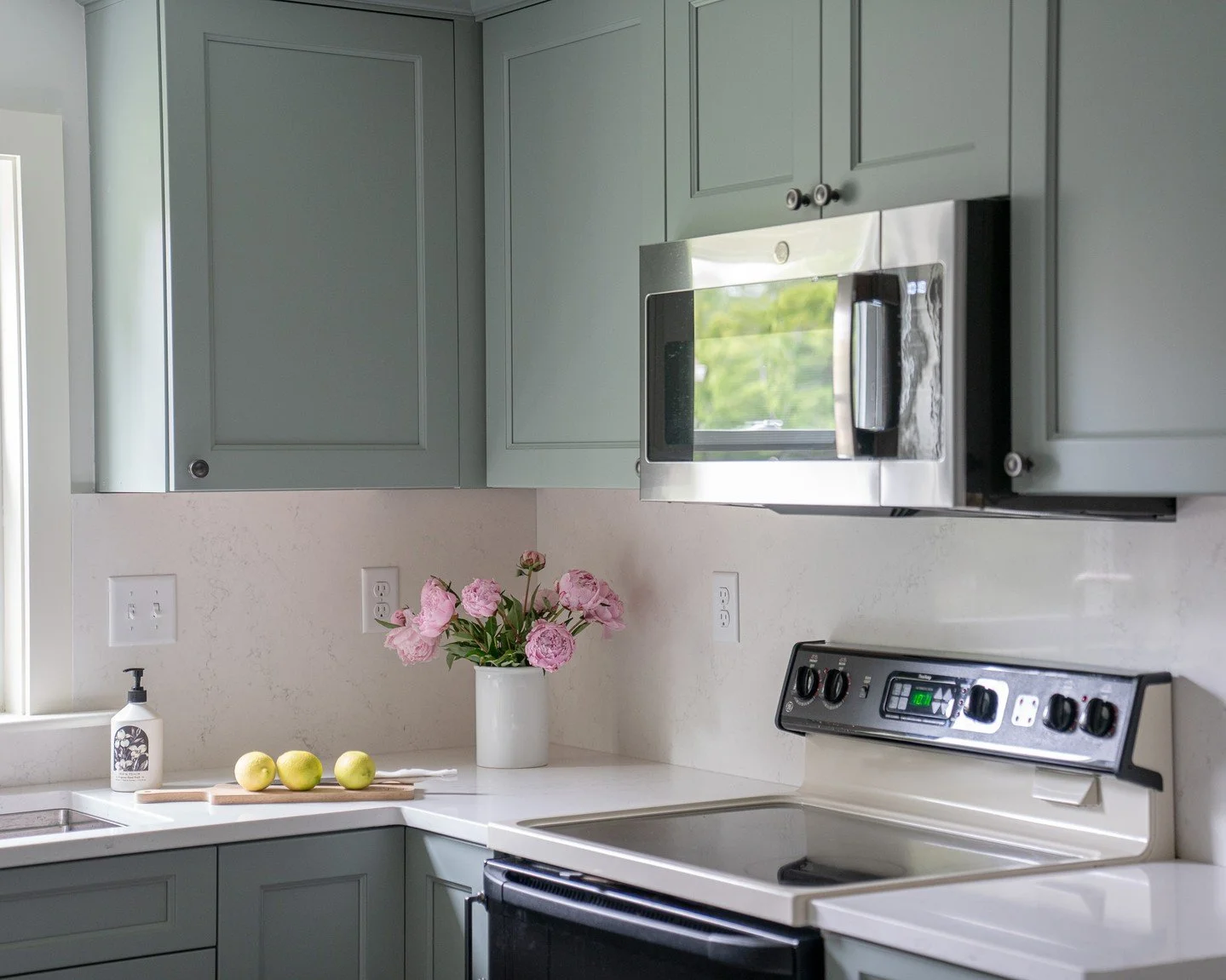 This compact kitchen proves that small spaces can be full of character. Soft green cabinetry adds a calming touch, while the accent tile brings in texture and personality. Thoughtful design choices make this kitchen both functional and inviting. #arc