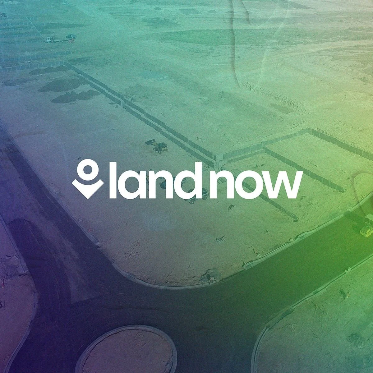 View of an empty construction site or foundation area, viewed from above, with the overlay text 'land now' and a location pin icon.