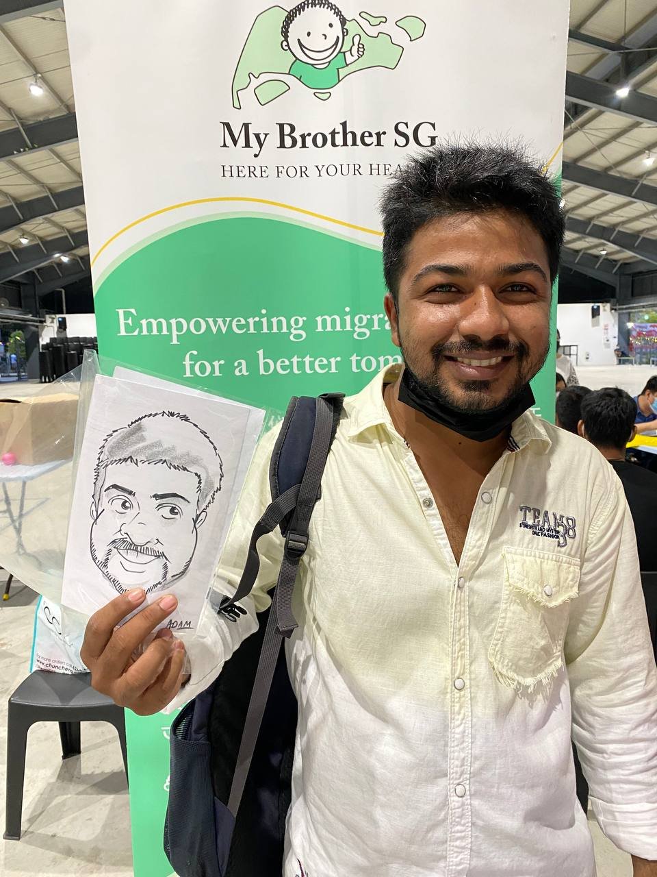 Migrant workers holding caricature drawings at Cochrane RC 3.jpeg