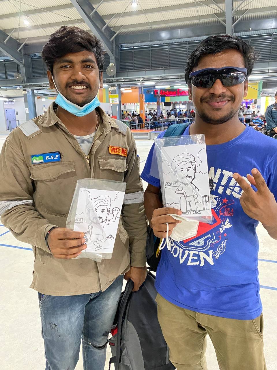 Migrant workers holding caricature drawings at Cochrane RC.jpeg