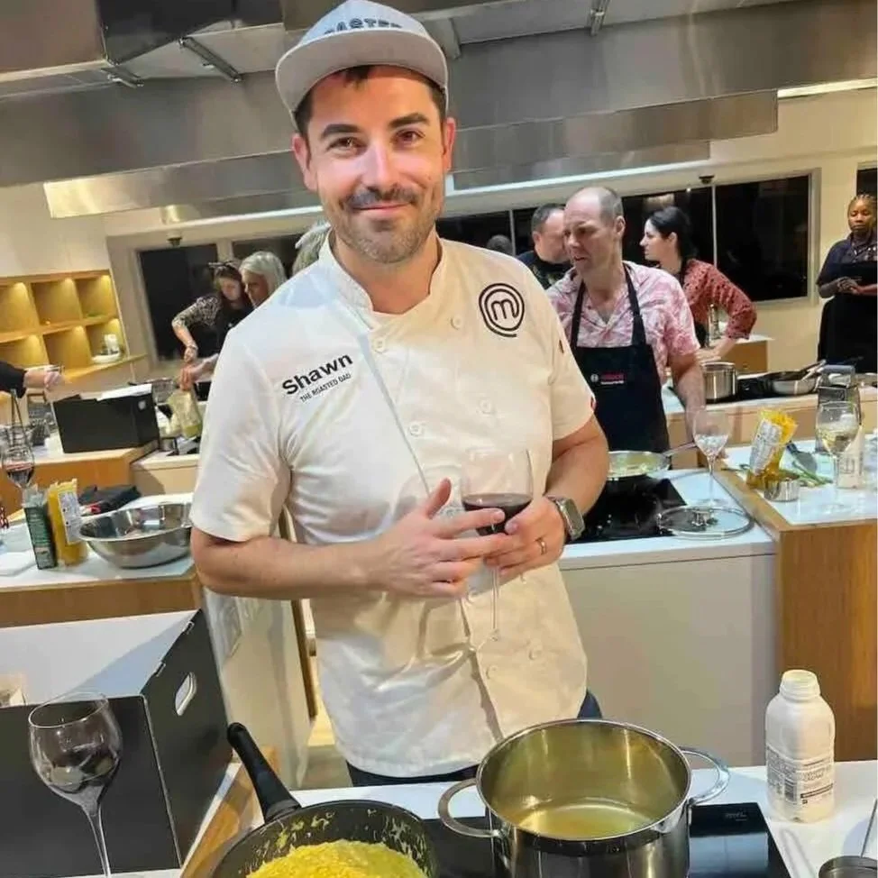 Shawn Godfrey in his MasterChef Chef's jacket at a cook-with-me demonstration for a corporate team building event.