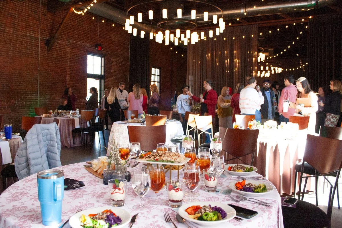 Guests of a corporate lunch and learn chat and socialize while waiting for the presentation to start. The event is being held in a historic industrial event space in German Village, Columbus, Ohio.