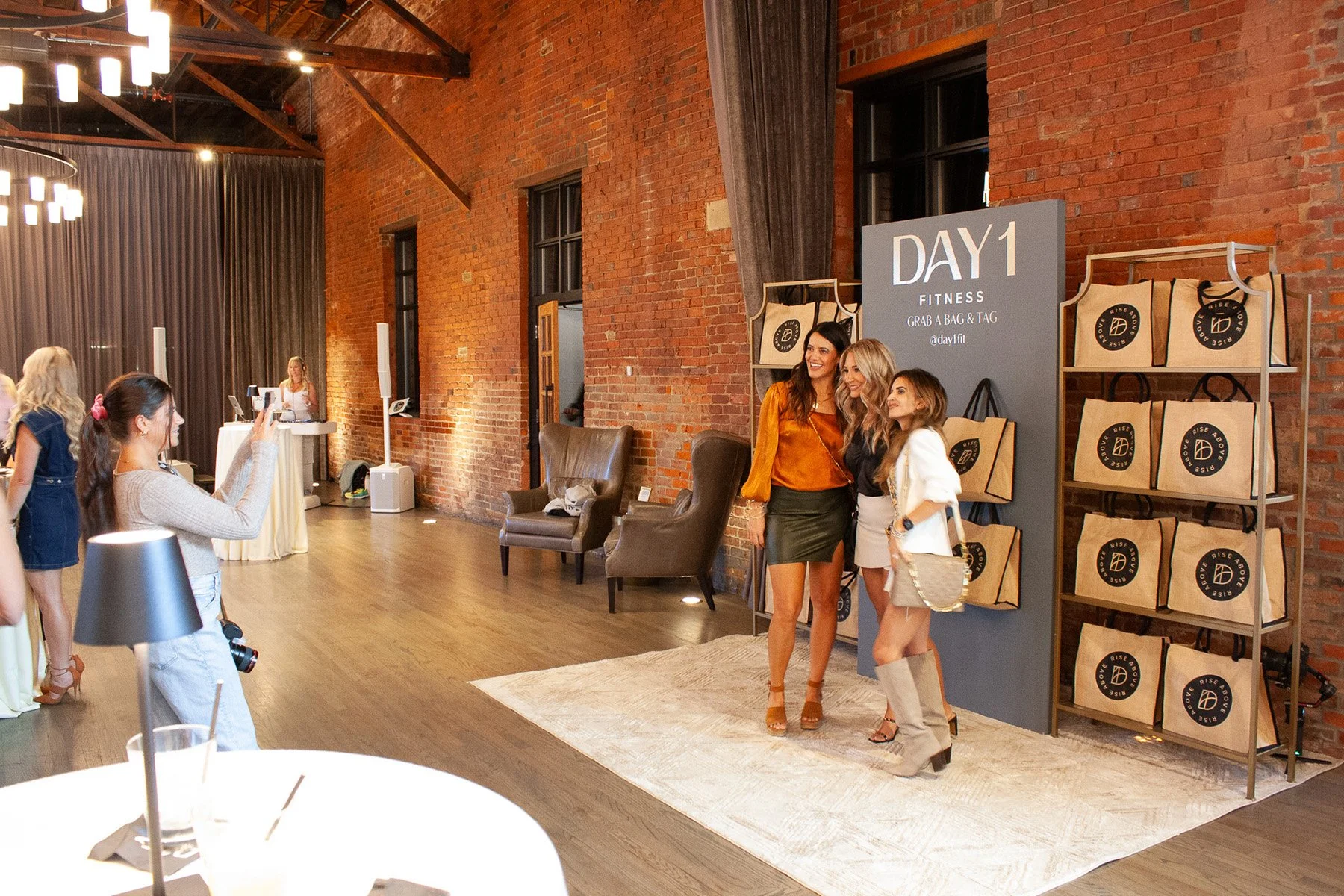 Guests pose for a photo in front of a display setup for a brand launch event hosted in a downtown event venue in Columbus, Ohio