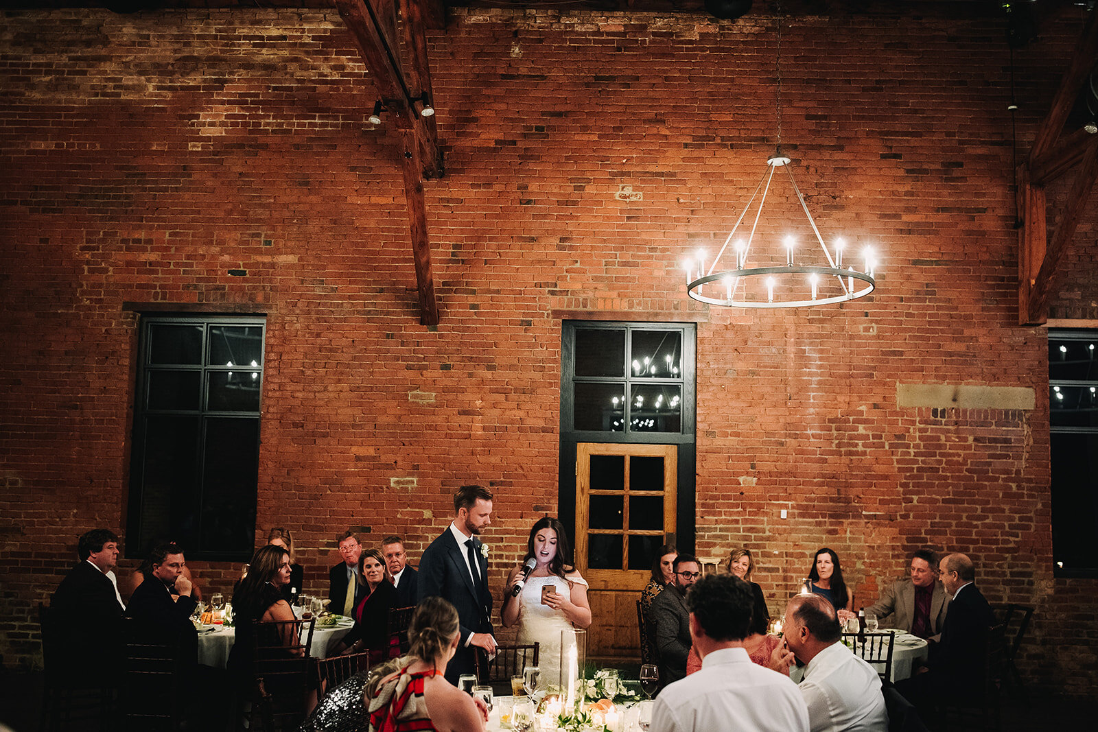 Admiring those industrial details 🖤🖤 

Photography: @derksworks 

Image descriptions:
Image one: A wedding reception at High Line Car House. A bride and groom reads a speech together, standing, against a brick wall. In the foreground, guests sit at