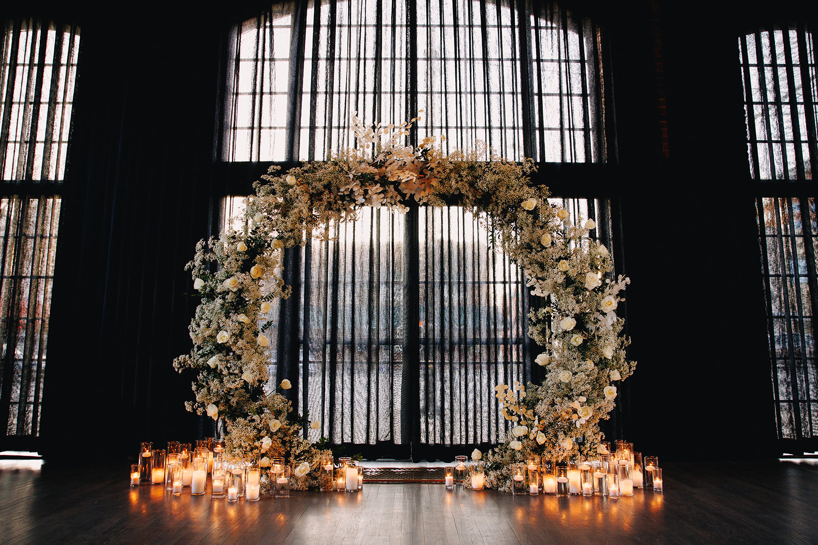 Details from Alonzo &amp; Jaclyn's ceremony &amp; reception 🖤🖤🖤

Photography: @derksworks 
Florals: @madisonhouseflowers 

Image descriptions:
Image one: A wedding ceremony arbor set up against a wall of arched windows. There are sheer black curta