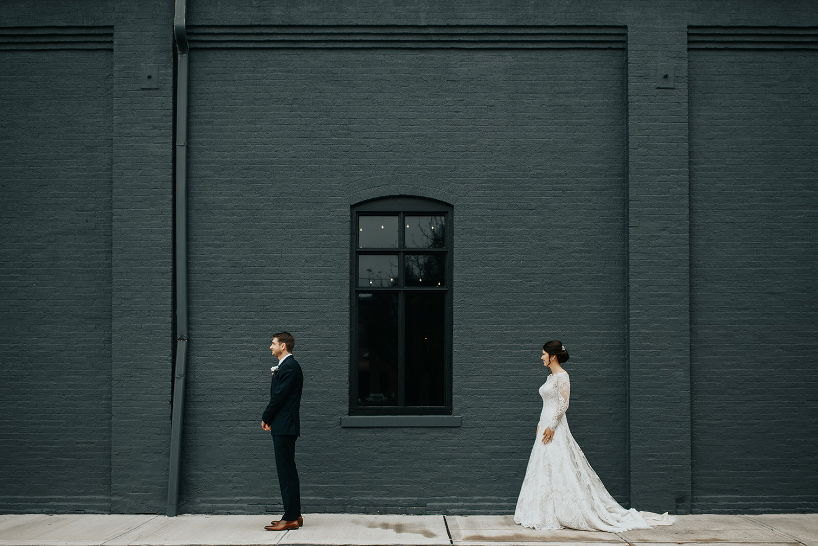 First looks with the beauty of High Line at your back 🖤🥰 Photography by @theoryimage. 

Image descriptions:
Image one: A bride and groom stand several feet apart, with the groom's back to the bride. A window is framed between them. 
Image two: A cl