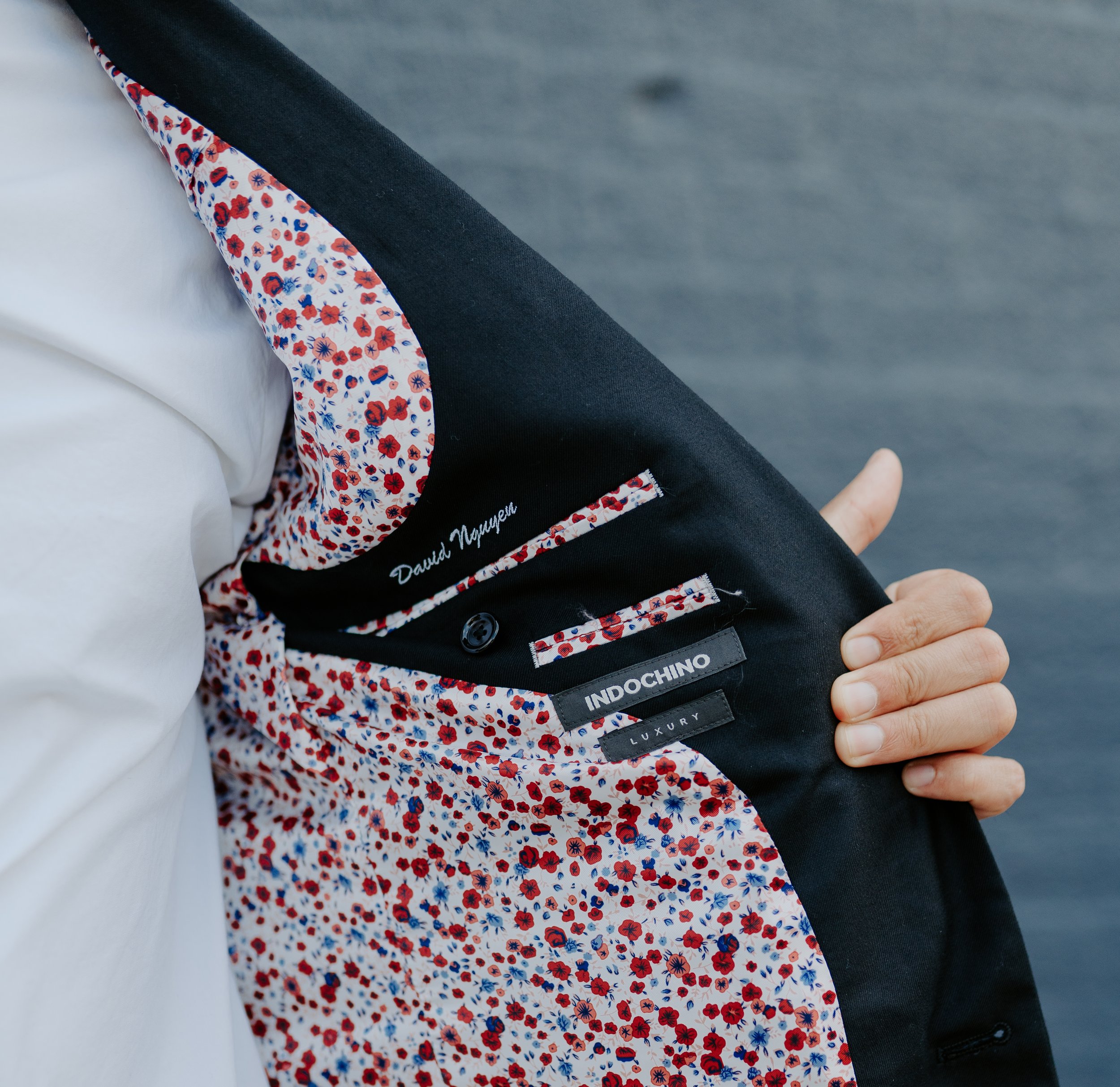  A groom opens up the side of his jacket, showing off a floral print lining and bespoke lettering spelling his name. 