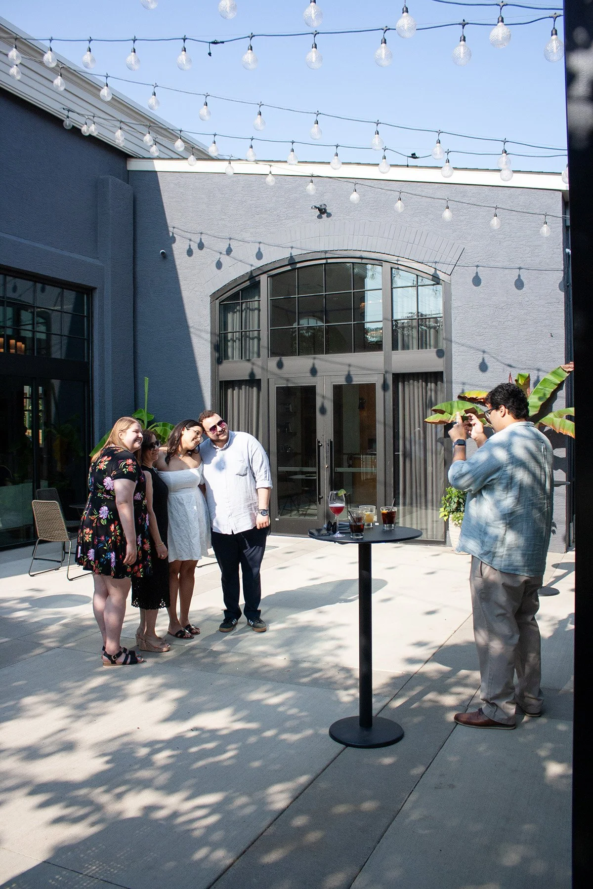 A group of students gather together for a photo at a graduation party on the patio at High Line Car House in Columbus Ohio
