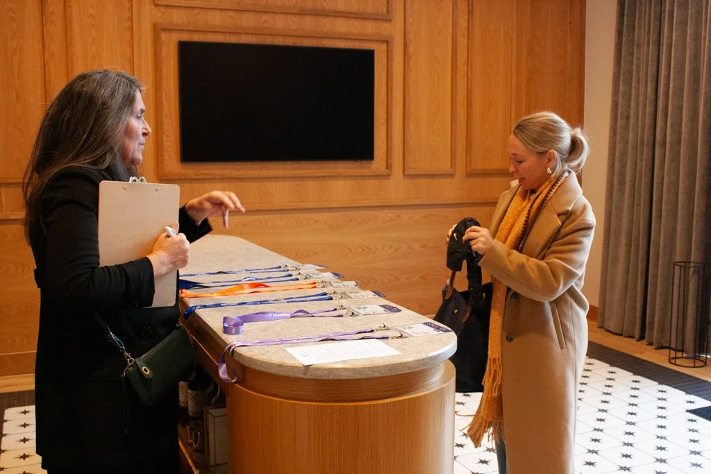 A guest checks in with a greeter for a corporate networking event at High Line Car House.
