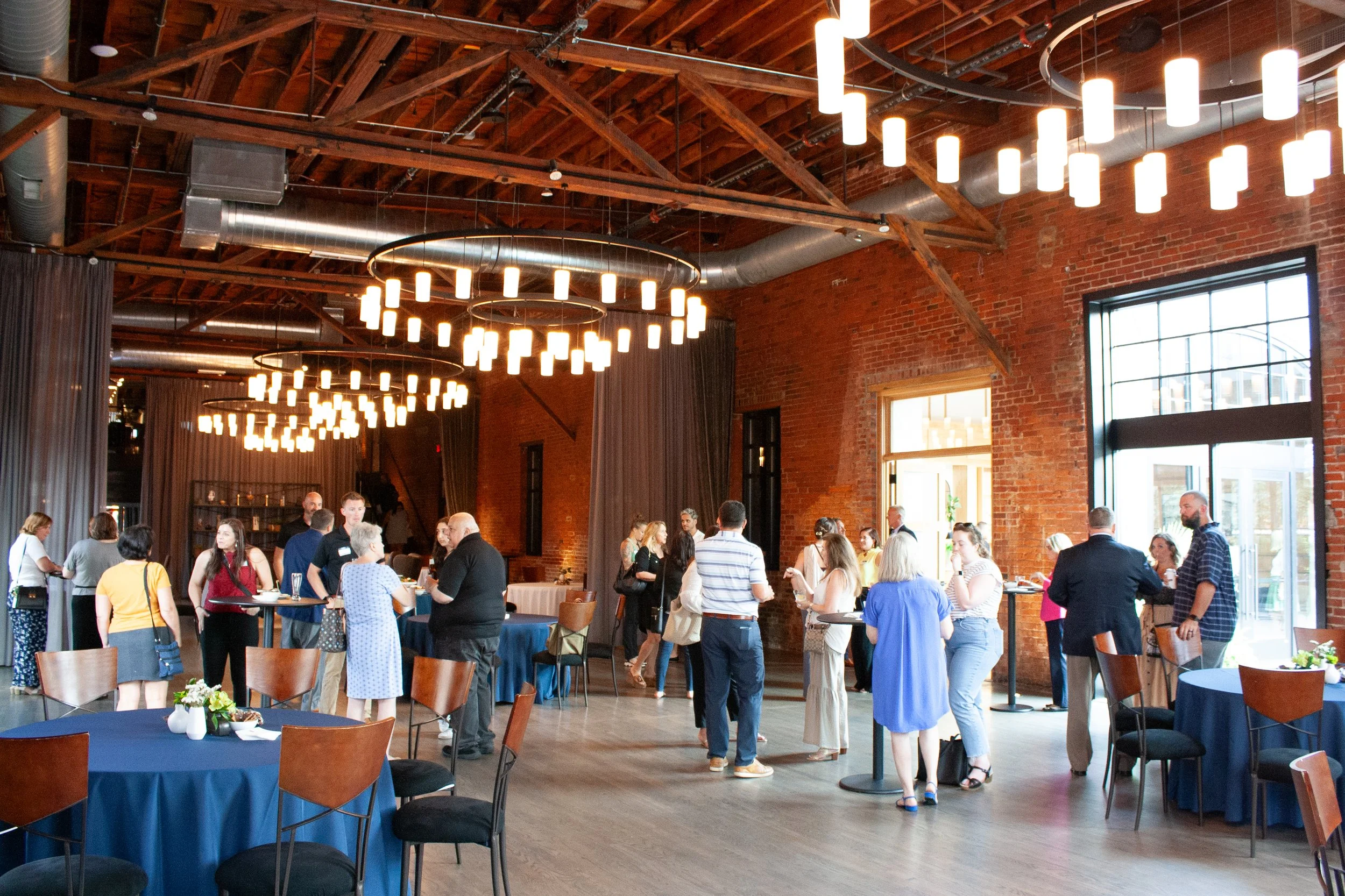 A spacious event venue with historic charm and brick walls in downtown Columbus, Ohio hosts a corporate happy hour.
