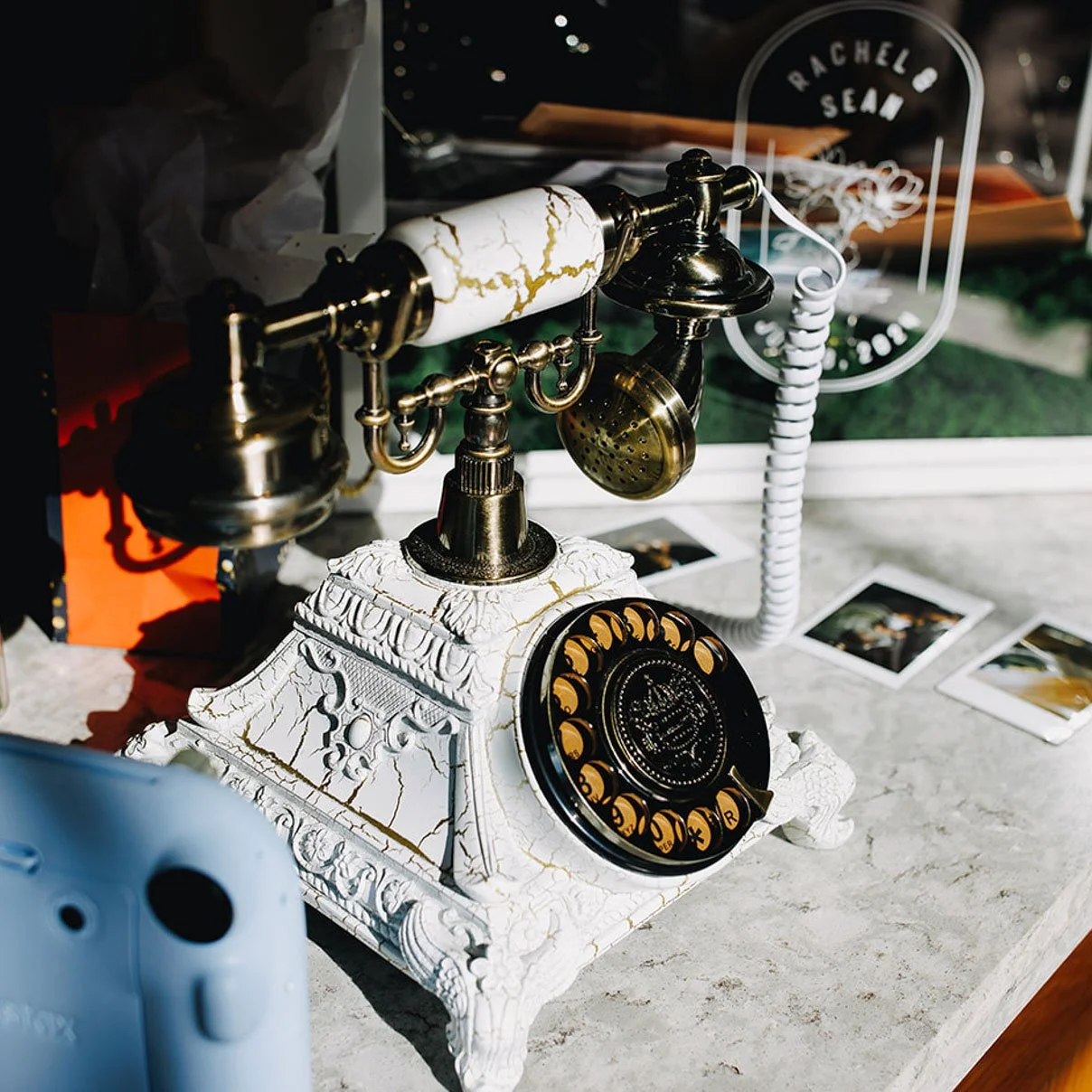 A rotary phone sits on the bar in High Line Car House's grand entrance foyer. Some polaroid photos are scattered in the background.