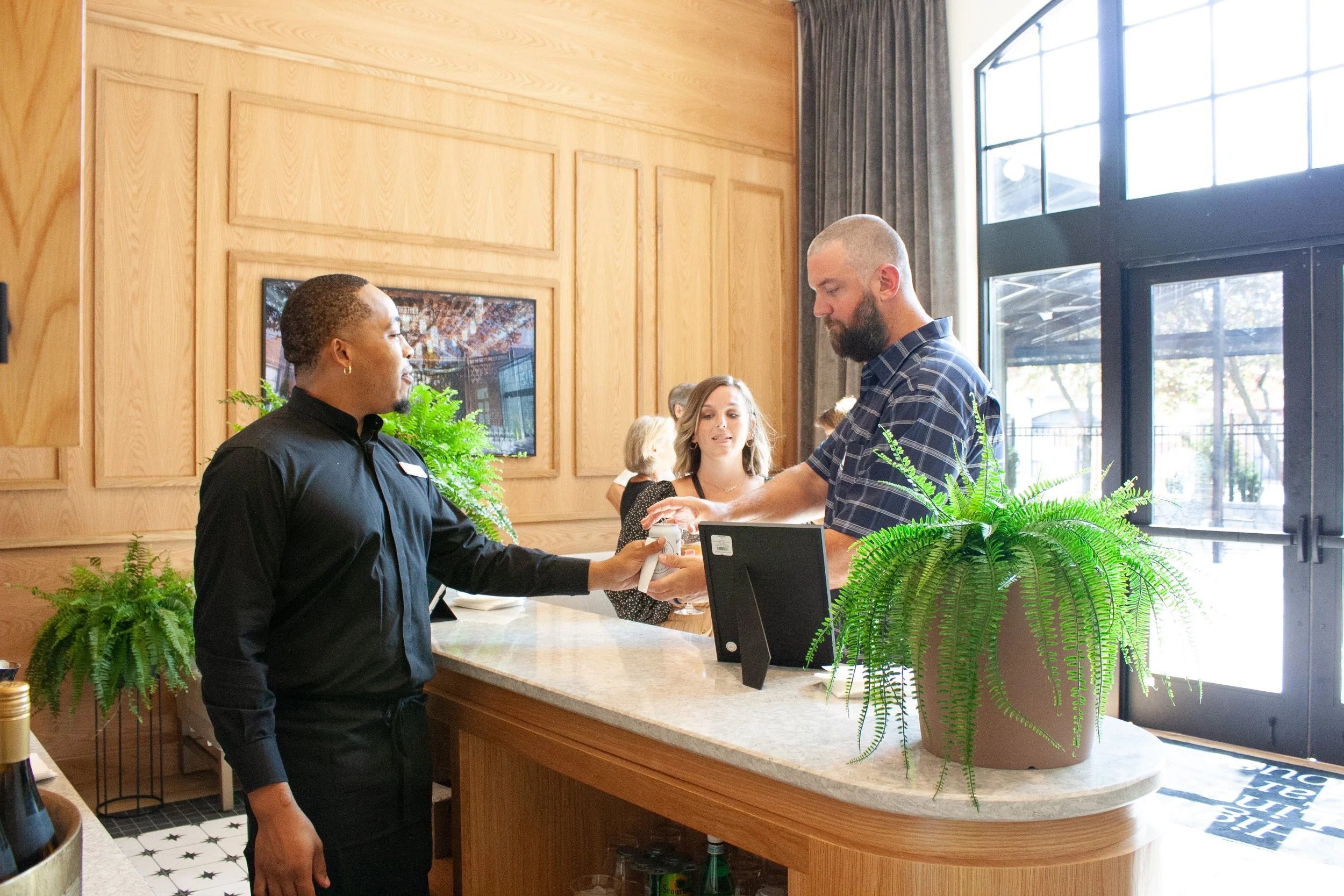 A bartender serves guests a welcome drink at a corporate happy hour hosted by a historic event venue in the German Village of Columbus Ohio.