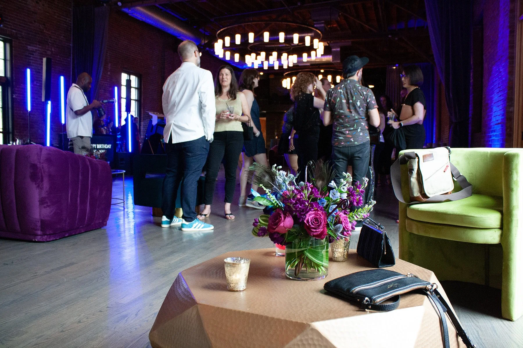Event guests mingle at a peacock-themed birthday party in a large event space in downtown Columbus Ohio