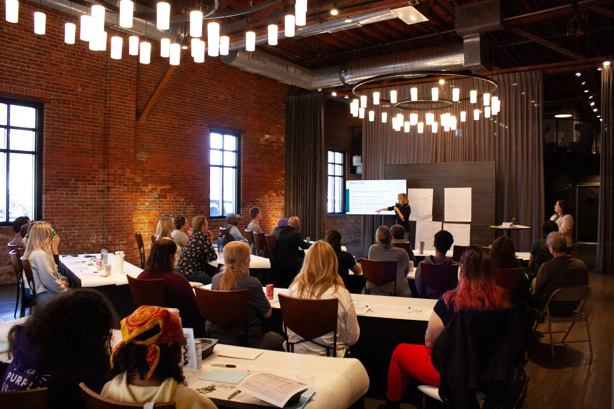 Someone gives a presentation at a company meeting in the spacious and versatile High Line Car House, an event venue in Columbus, Ohio.