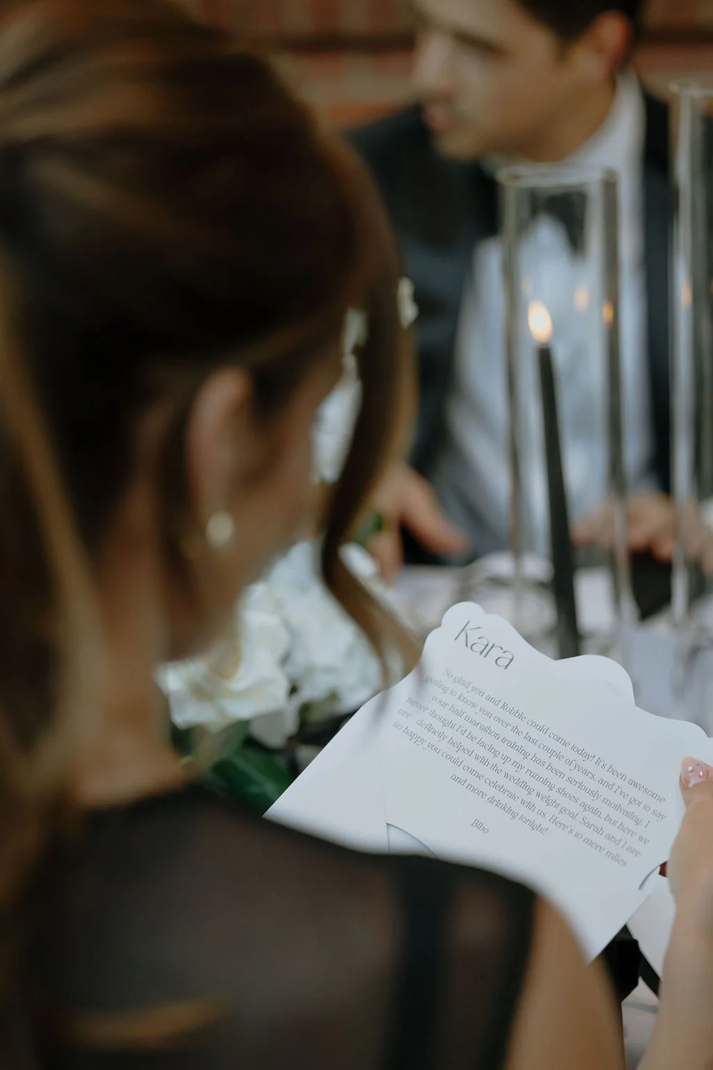 A view over a guest's shoulder as they read a personalized note at a wedding reception in Columbus, Ohio.