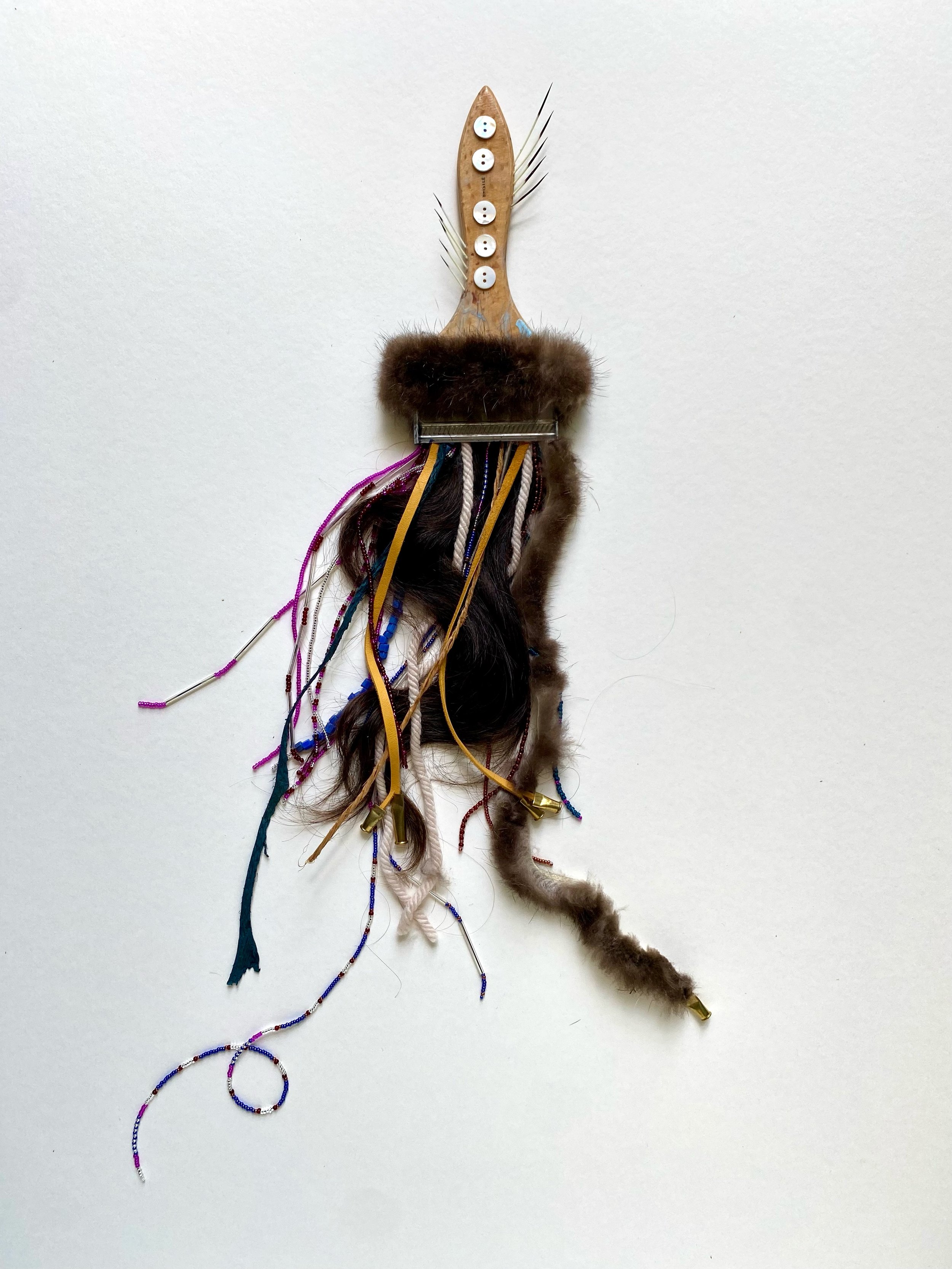 Bristle, 2025. Reclaimed paintbrush, fur, quills, hair, glass beads, mother of pearl buttons, deer leather, merino wool, cedar bark, salmon leather, .22 bullet casings