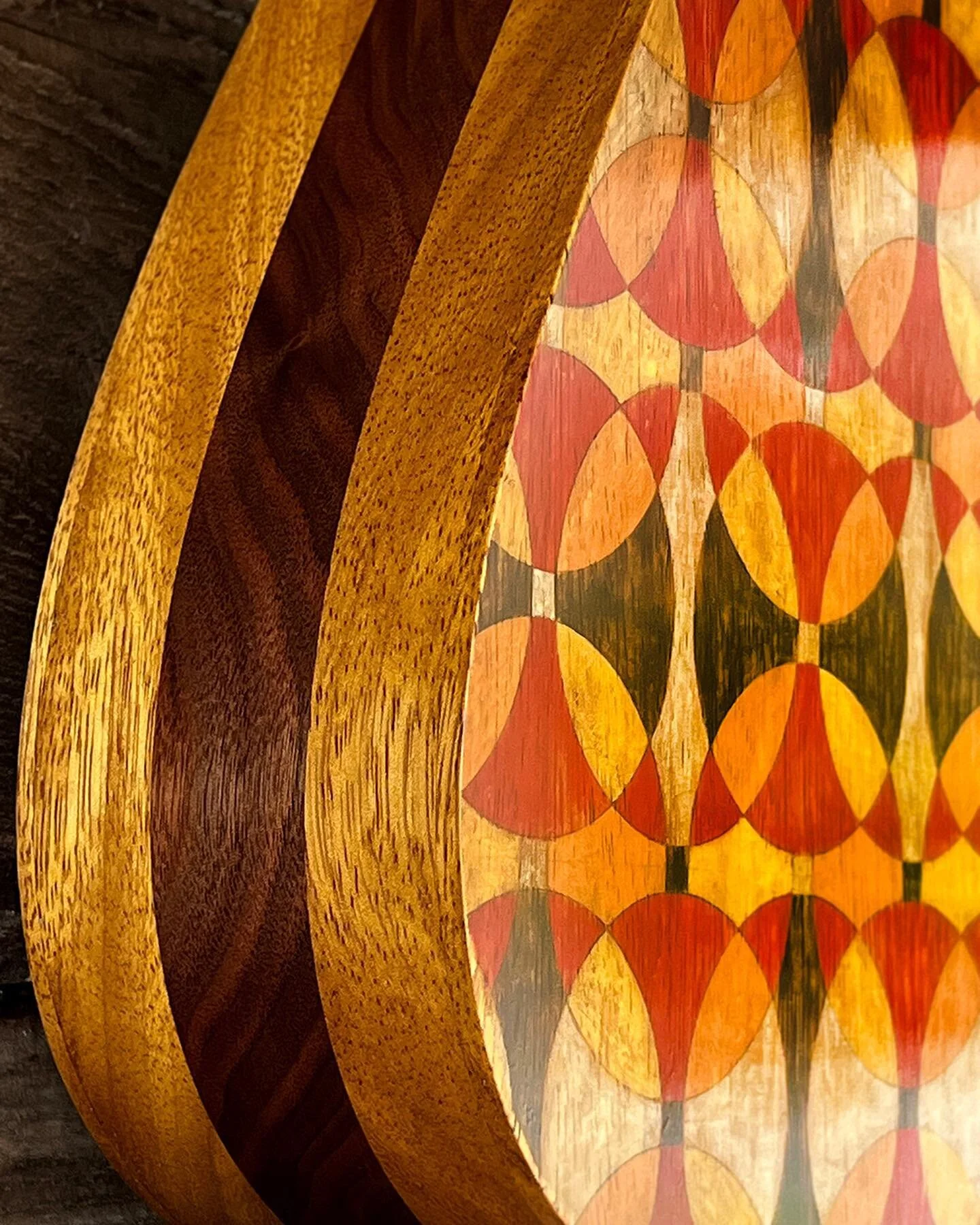 Here is an acoustic/electric, three string guitar with the body shaped like a guitar pick. Walnut and African teak was used with padauk accents. A guitar pick is inlaid at the top. The back is hand painted and distressed to imitate inlay. 

#threestr