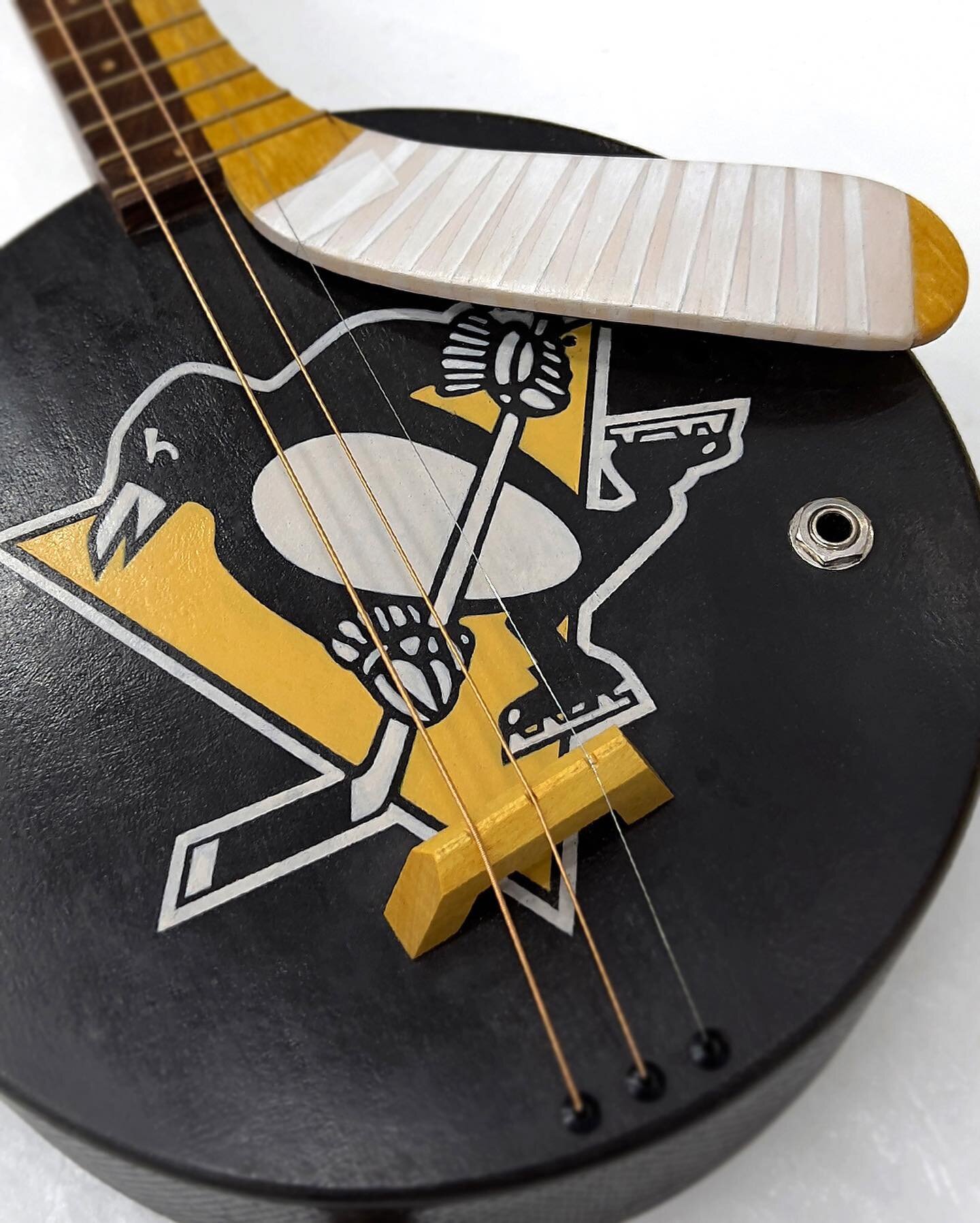 For Pittsburgh @penguins hockey and guitar fans alike! The textured hockey puck body of this three string acoustic/electric guitar is made of maple. The neck is walnut, and the hockey stick is yellow heart. The Penguins logo, lettering and tape are h
