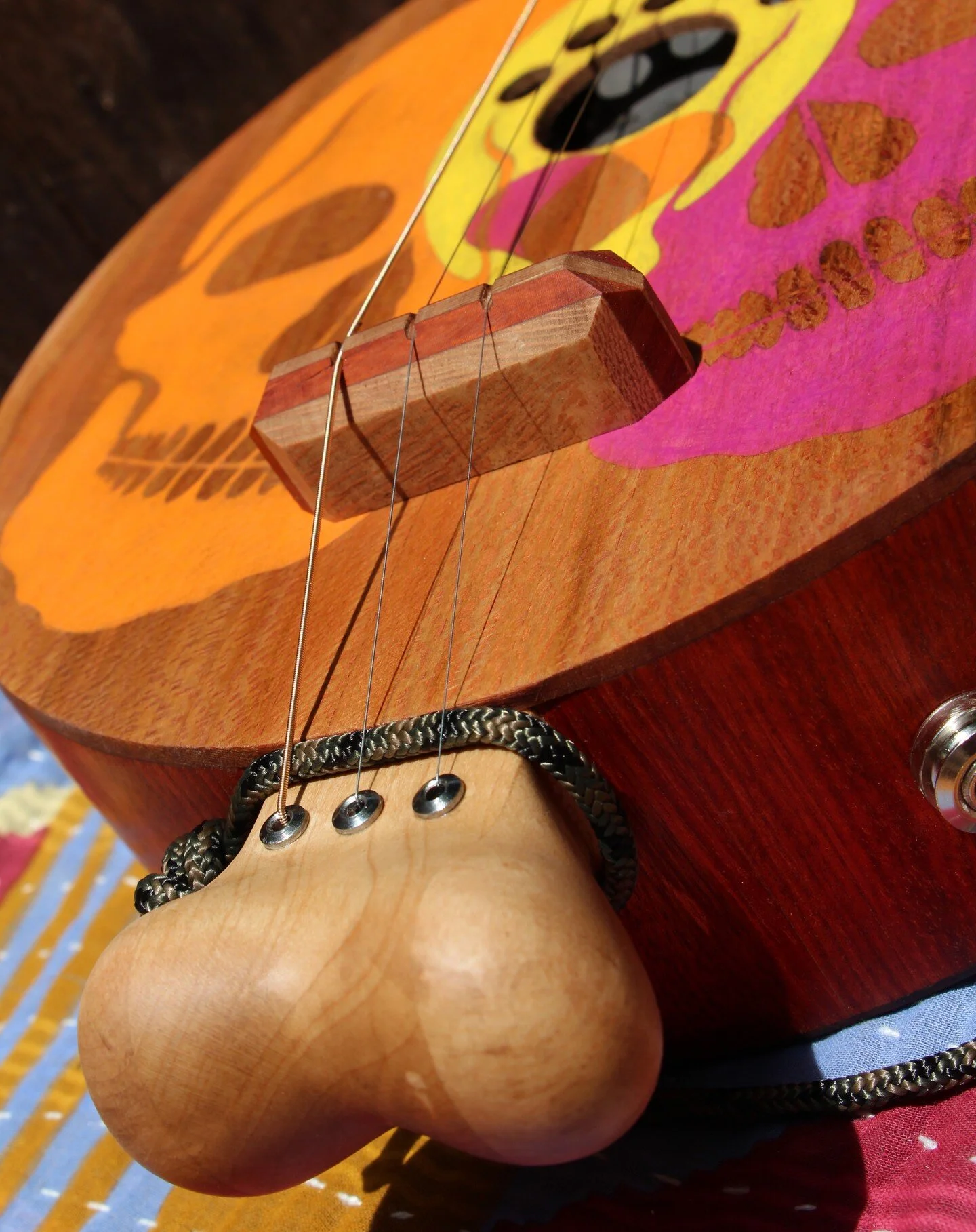 This acoustic/electric, three string, fretless guitar with its skull and bones motif was inspired by the work and creativity of Freeman Vines. Hard rock maple, padauk and sycamore woods were used for this guitar. The bone neck is hand carved. #threes
