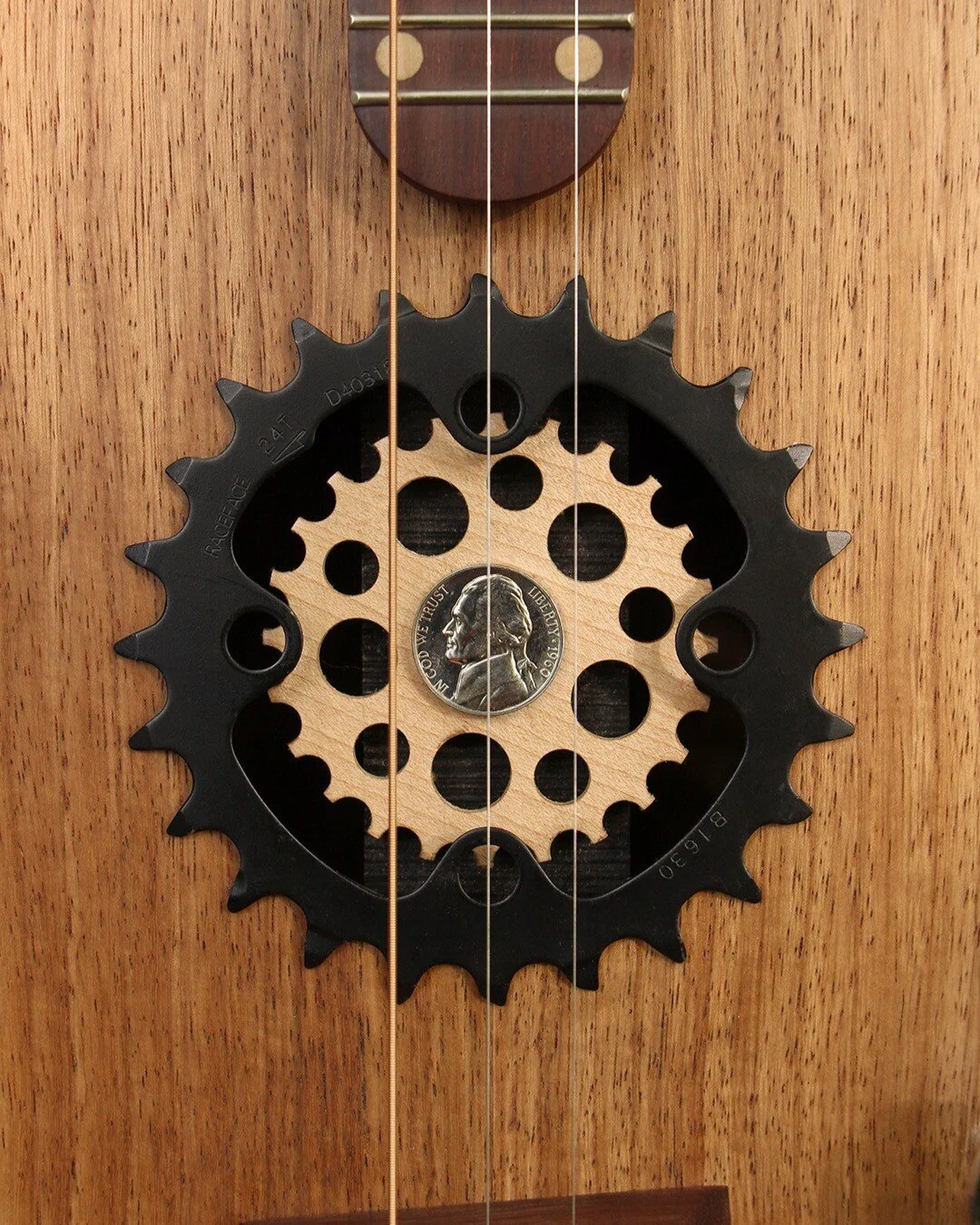 I made this acoustic/electric, three string guitar for a cycling and Pontiac Firebird fan. The woods used for this guitar are hard rock maple, kiaat, and katalox. The volume and tone knobs are from a &rsquo;67 Firebird radio, with a Firebird gas tank