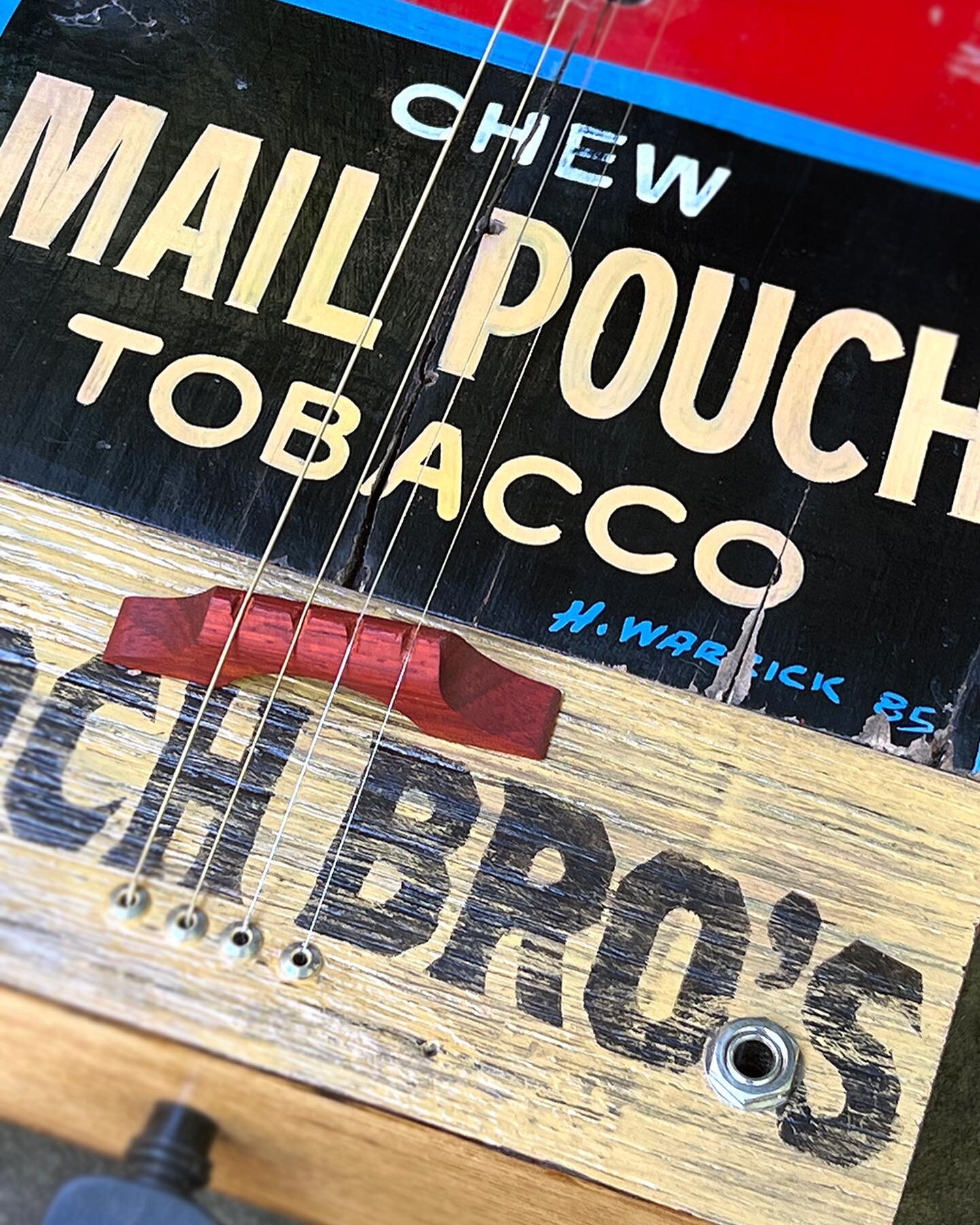 This four string, acoustic/electric guitar was made possible by Barb for the Mail Pouch bird house panel signed H. Warrick &rsquo;85, American chestnut from Hal, white oak recycled barn wood from John, and the scroll pegbox and tuning peg from Fred. 