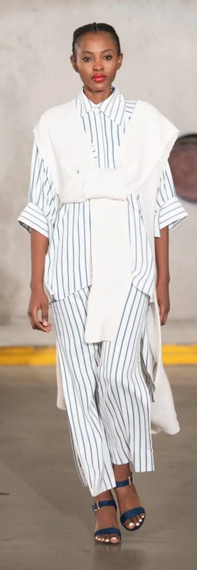 Model in white and blue striped outfit on runway
