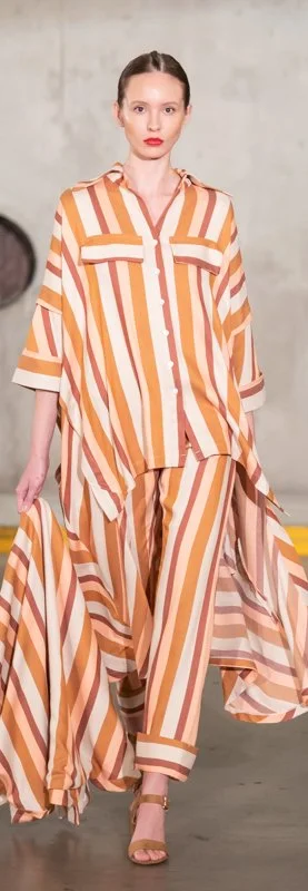 Model on runway wearing striped tunic and pants